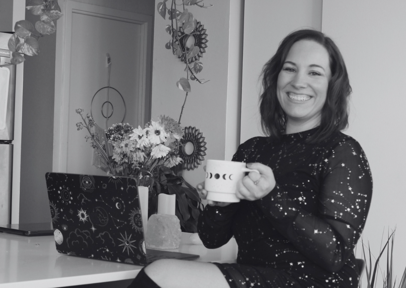 Gigi Steinbarth, founder of Own Your Alchemy, sitting at her desk with a laptop and coffee mug — the real person behind your spiritual business strategy