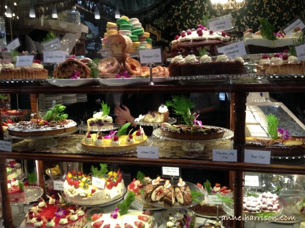 A variety of cakes and pastries on display in a shop window
