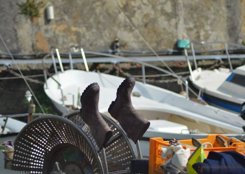 A pair of gumboots dry in the sun on a fishing boat.
