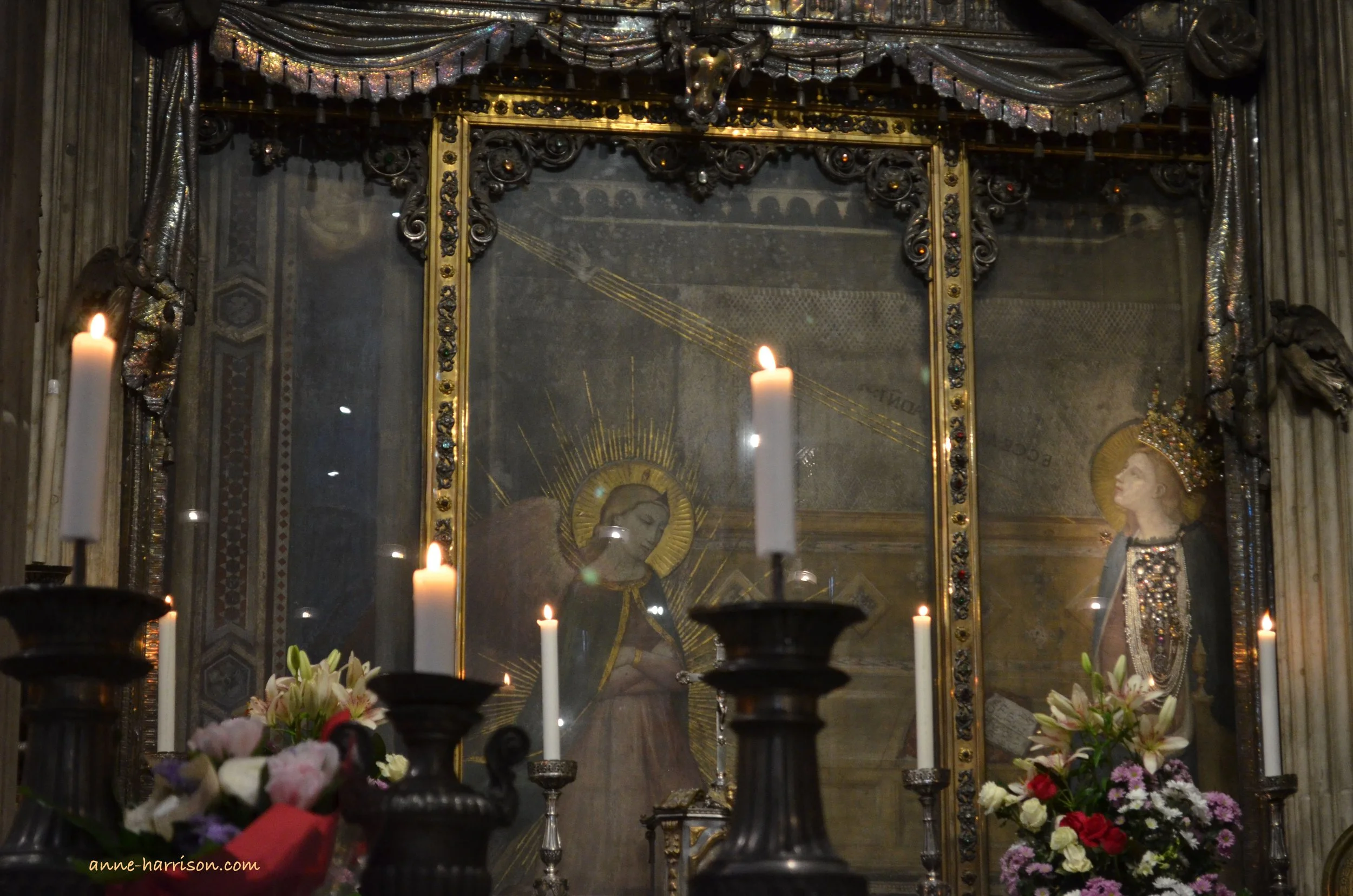Fra Bartolomeo’s The Annunciation, framed by candles and flowers.