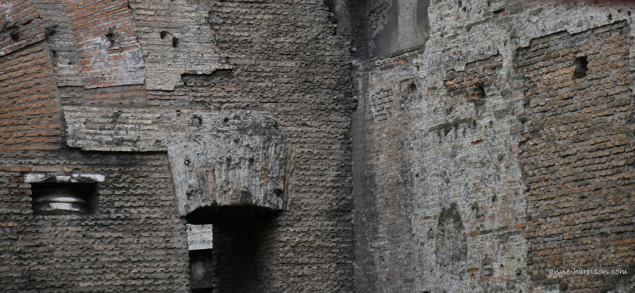 Details of an old brick wall in Rome, including arches.