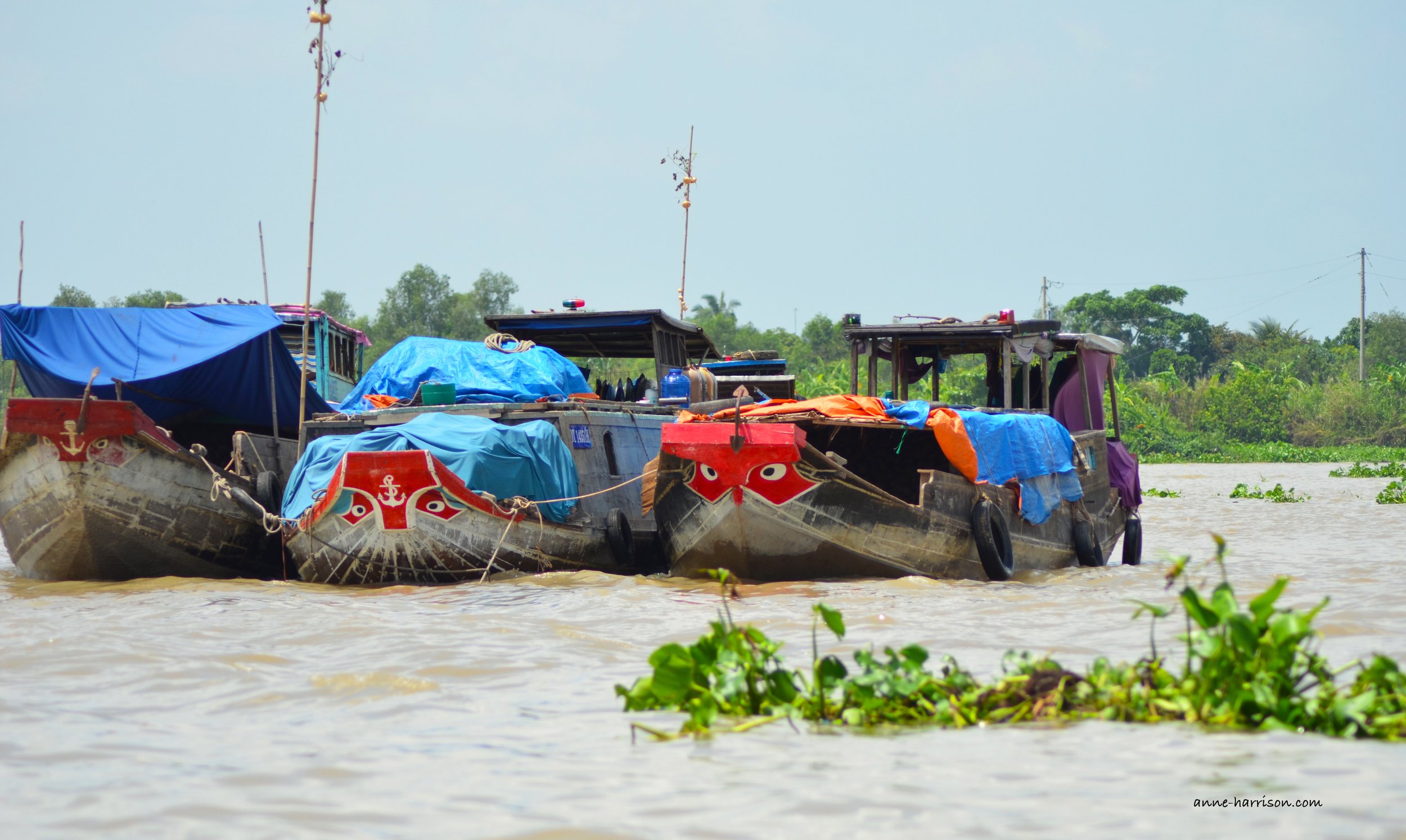 Three boats tied together near a mooring on the Mekong.