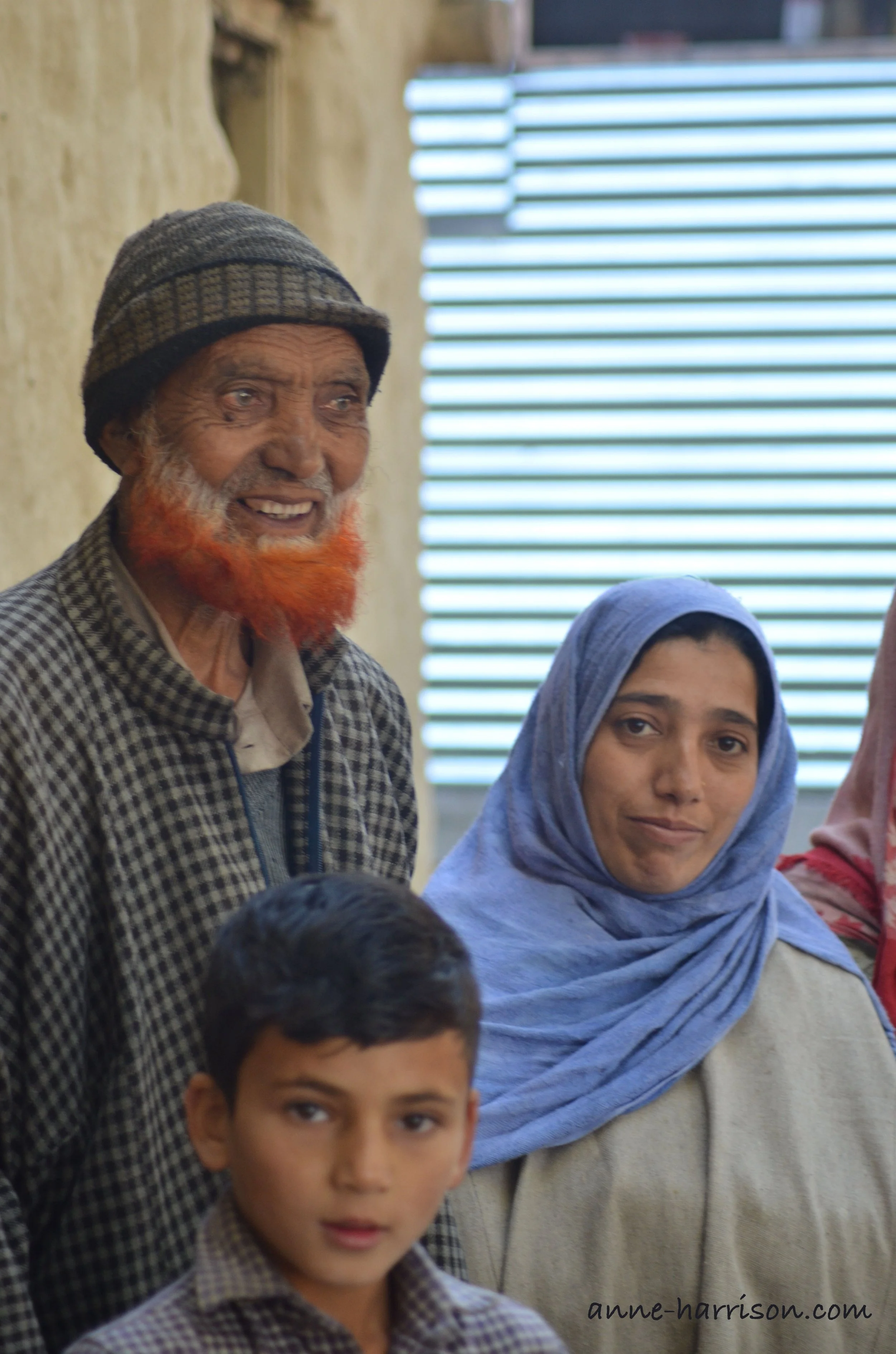 A proud grandfather with a henna-dyed beard and his family