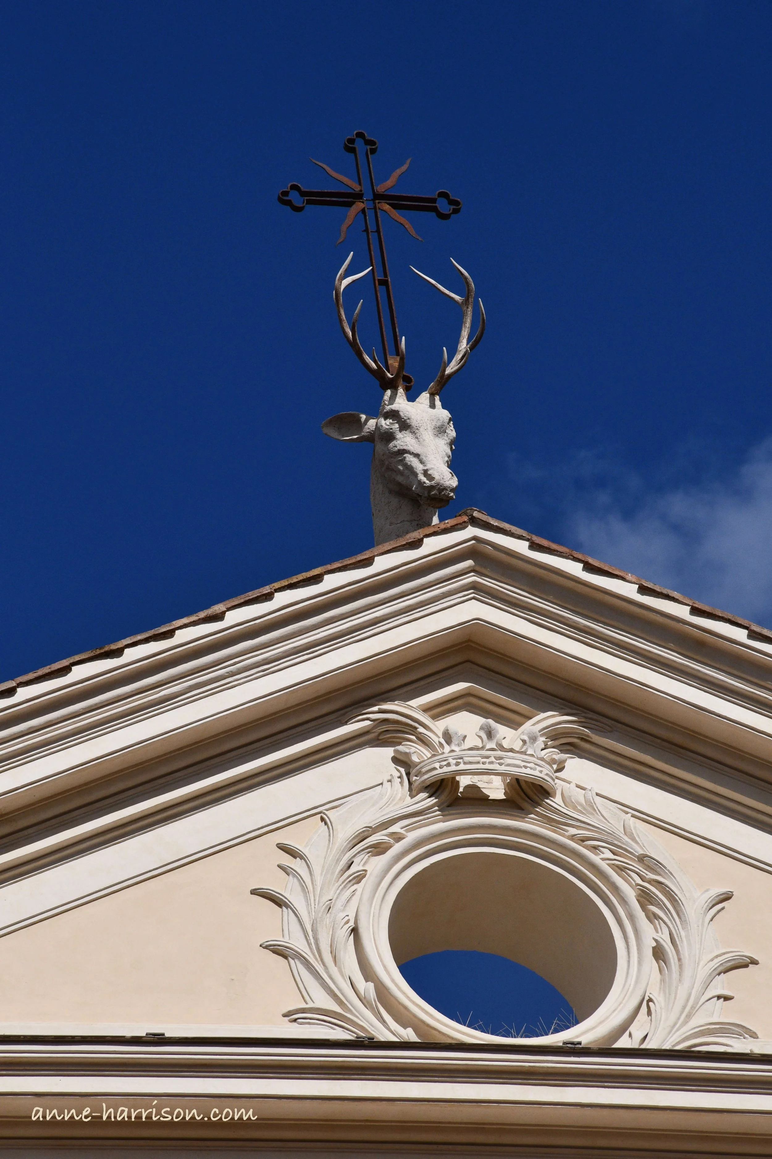 A statue of a deer's head with a cross between the antlers, on top of the Basilica di Sant'Eustachio, Rome on top of