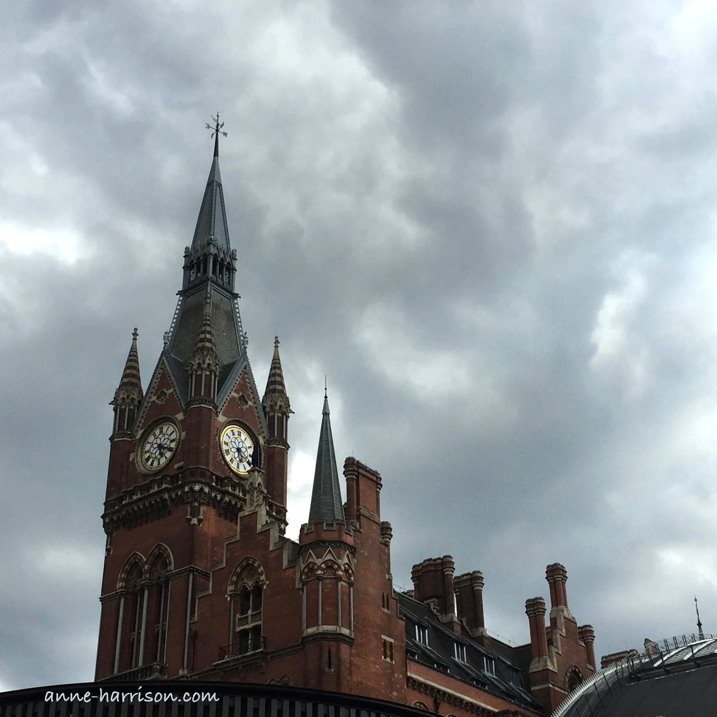 The clock tower and roofline of St Mary's Hospital Paddington, London. The sky is filled with grey clouds.