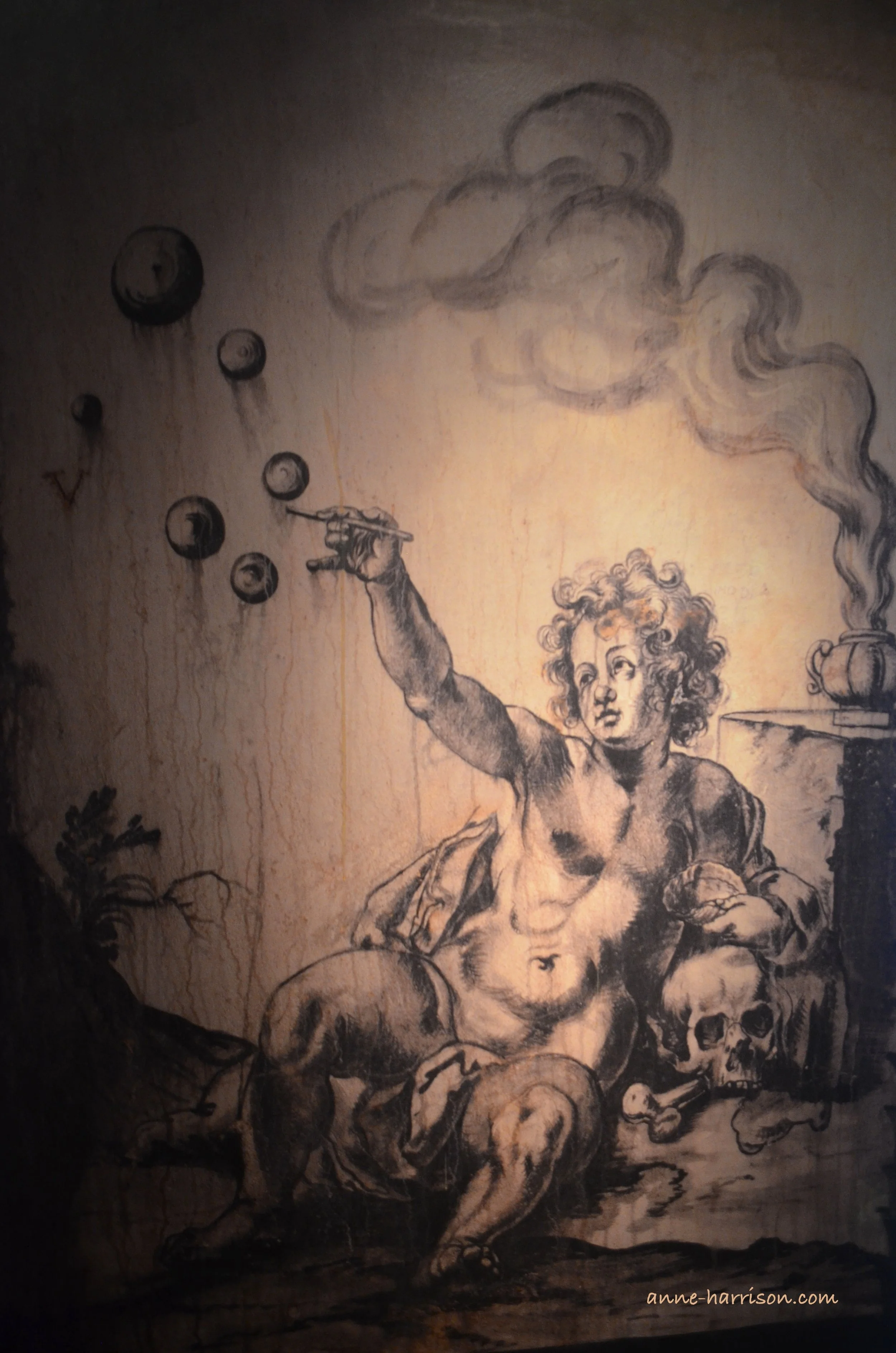 A charcoal sketch of a putti leaning on a skull