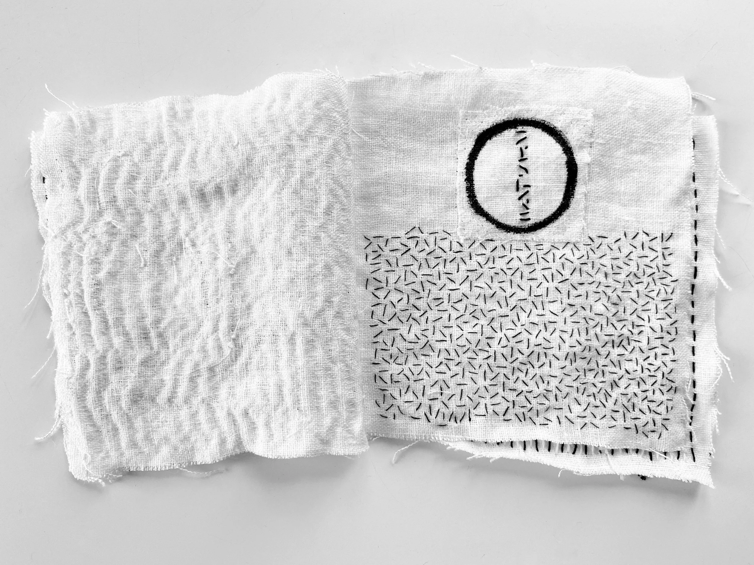 Black and white textile meditation book with Rustic, wabi sabi textile meditation book wtih an Ensō circle painting made by hand on white linen and slow, hand stitching seed stitch made by Emma Freeman, contemplative mixed media artist and teaching a