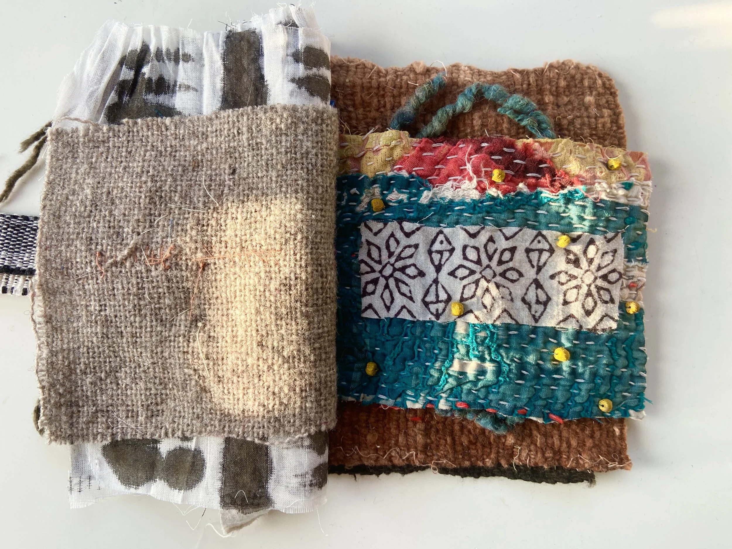 Rustic, contemplative mixed media textile books made by mixed media artist, Emma Freeman using vintage global textiles including mud cloth from Mali in Africa, batik fabric from India, vintage kantha cloth from India, wool yarn from a Peruvian frazad