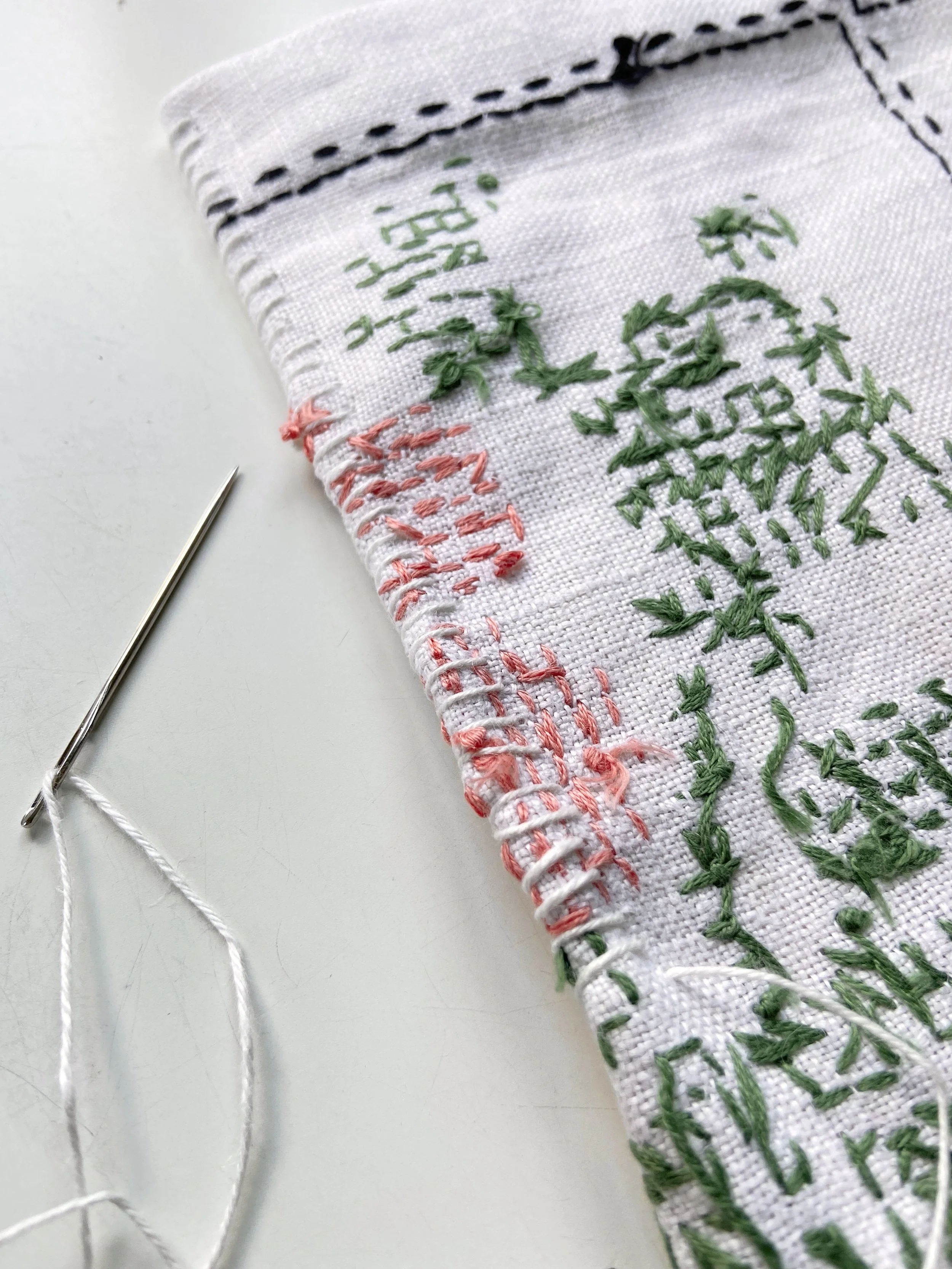 Vintage cross stitched embroidery linen tablecloth transformed into a slow stitched fabric meditation book by Emma Freeman, contemplative textile artist and mixed media artist in Wisconsin. She uses appliqué techniques and other intuitive hand embroi