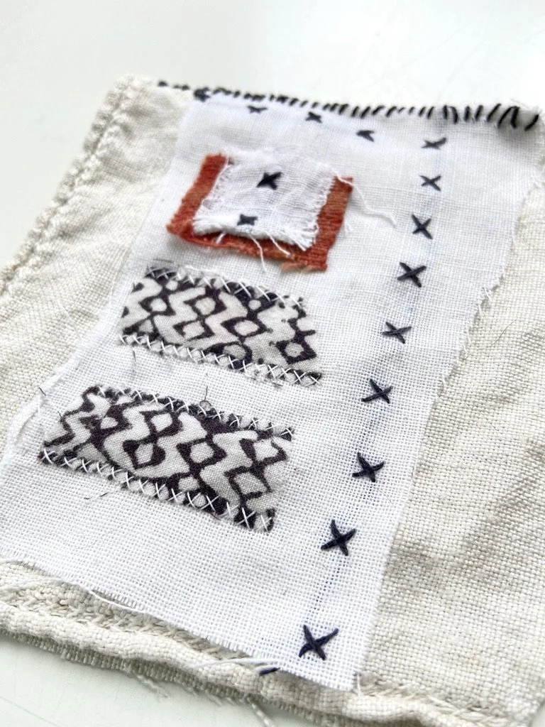 Fabric meditation book made by Emma Freeman using vintage cross stitched embroidered textiles, repurposed handmade batik clothing, a fragment of red dyed cotton from a vintage Peruvian woven wall hanging, vintage linen tablecloth scraps, hand spun na