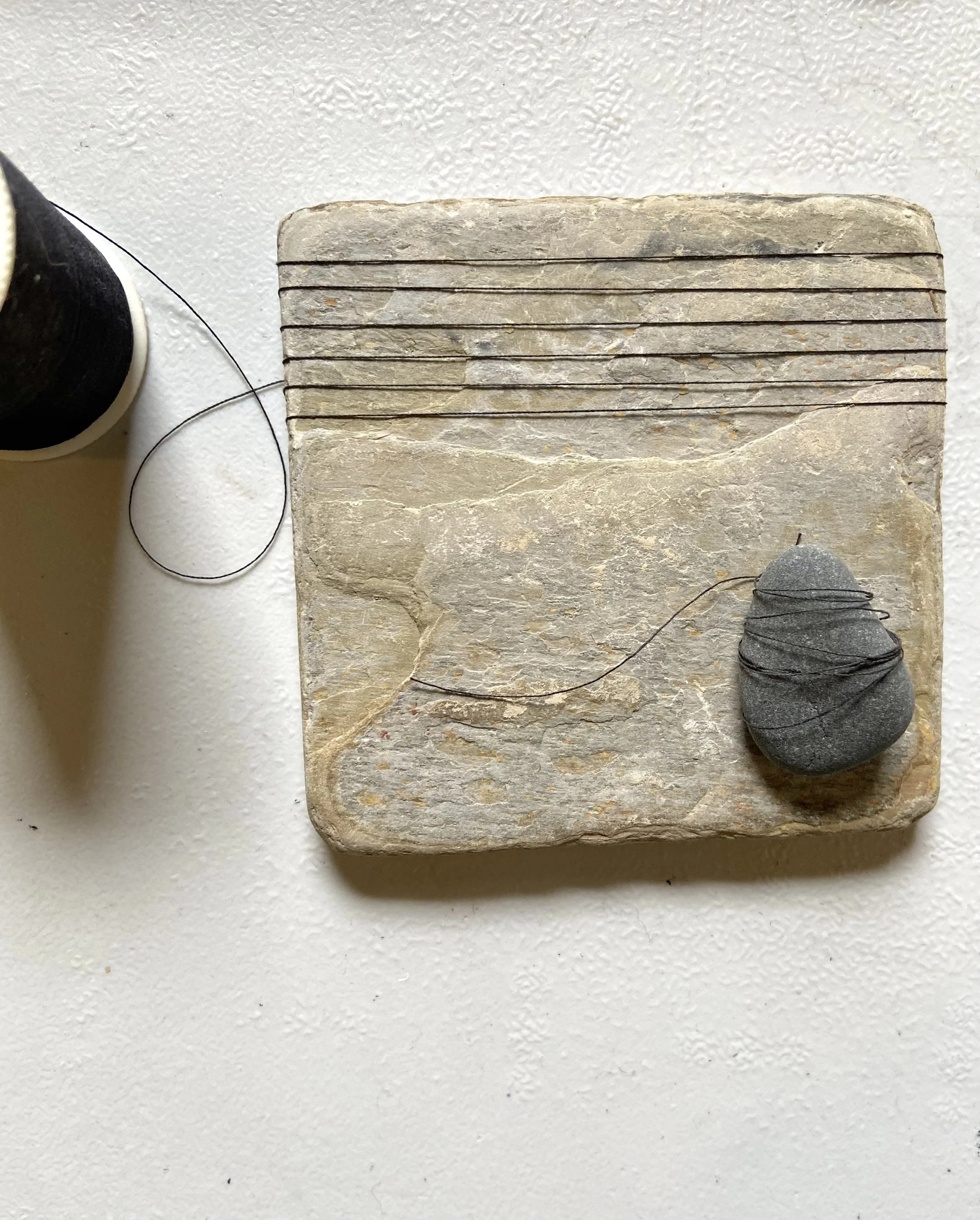 Zen contemplative assemblages of repurposed stone tiles, thread, gathered stones, nature connected art, meditative art, contemplative art, peaceful art, mixed media artist in Wisconsin, Emma Freeman Art, textile artist, art as spiritual practice