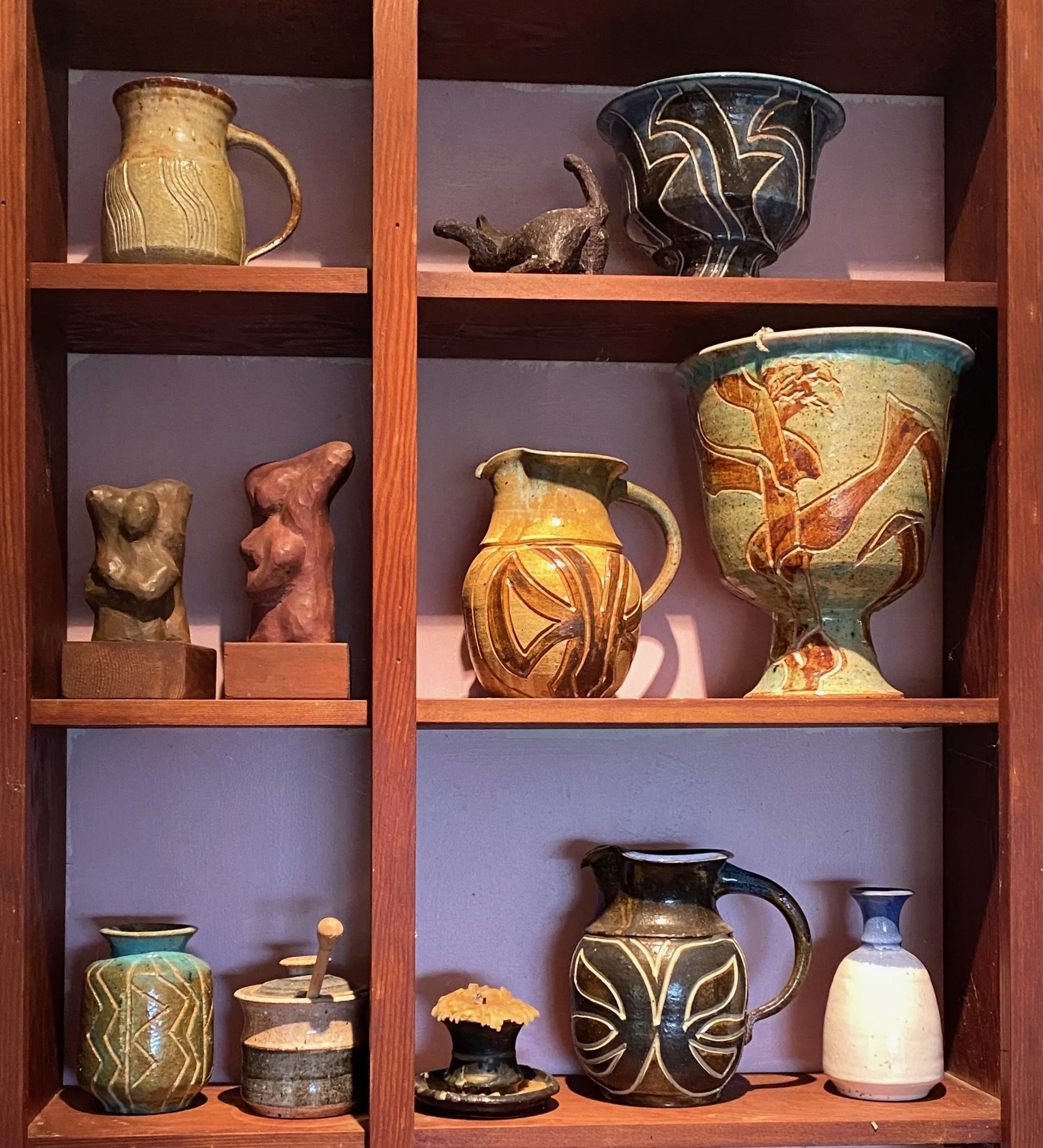Tall wooden shelves full of decorated pottery