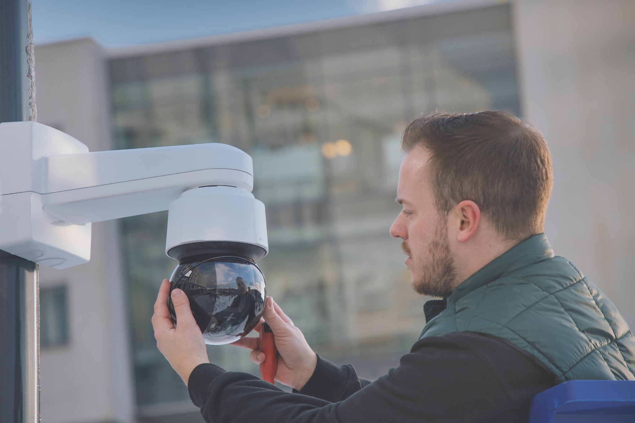 Technician installing and adjusting commercial security camera system