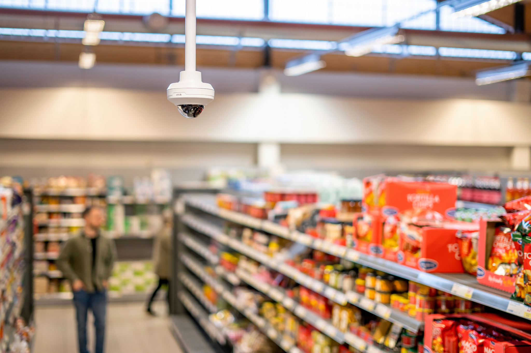 Ceiling-mounted security camera monitoring commercial retail space