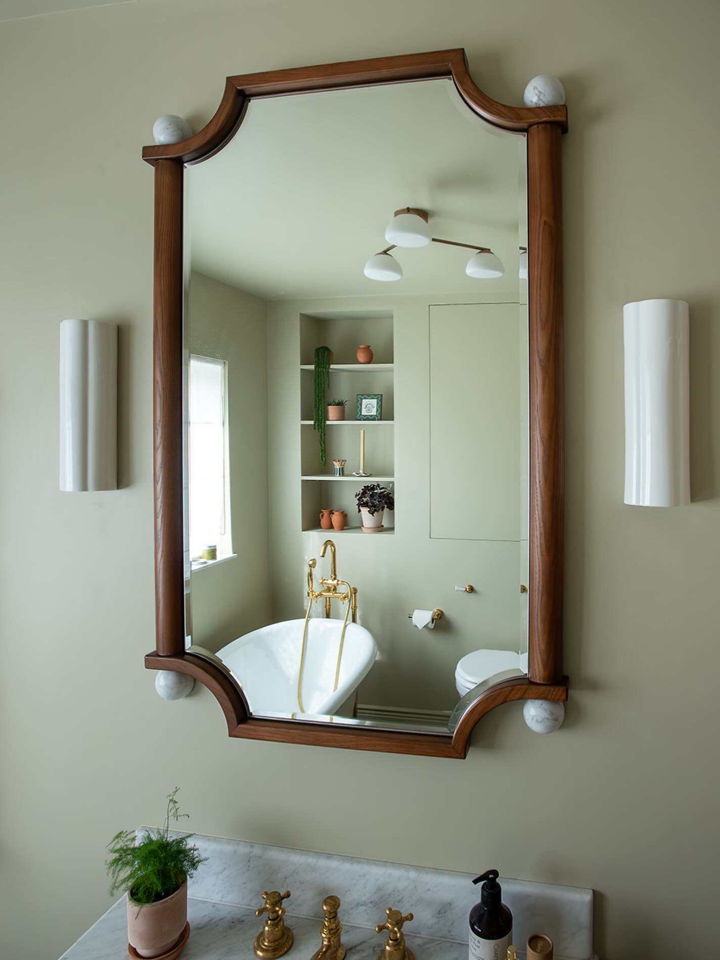 You might recognise some traditional shapes here. The framed mirror, the marble top, the brass taps. There&rsquo;s something familiar about them, but the softer palette and pared back detailing give the room a different energy.

When I design a space