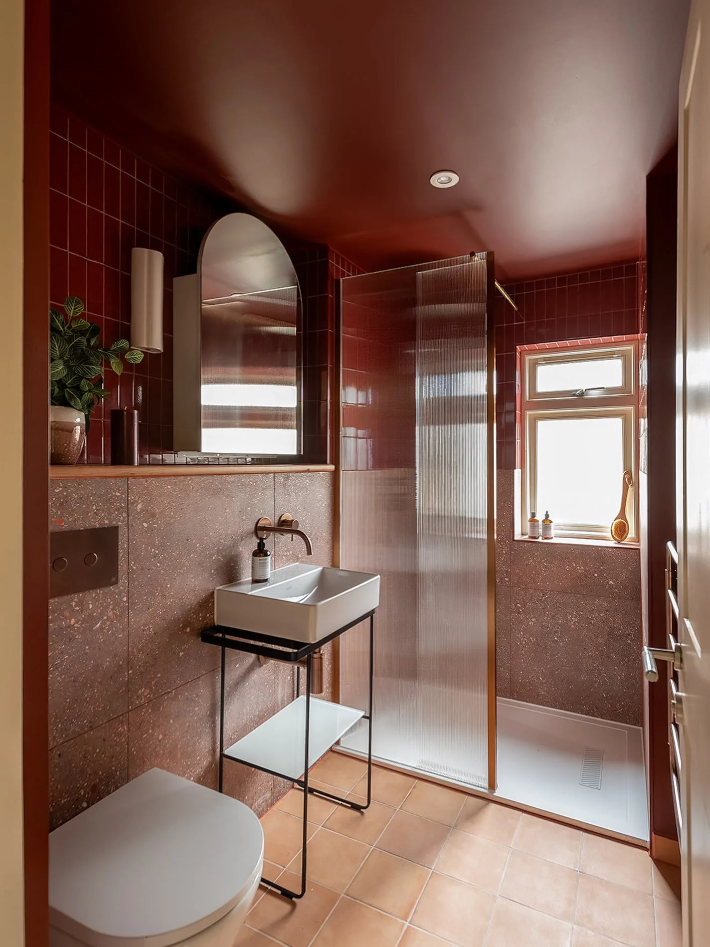 Want a small bathroom to feel more spacious? Think about where your lines stop and start. 

Rather than stopping the wall tiles behind the basin, we continued them at exactly the same height around the room and into the shower.

That uninterrupted ho