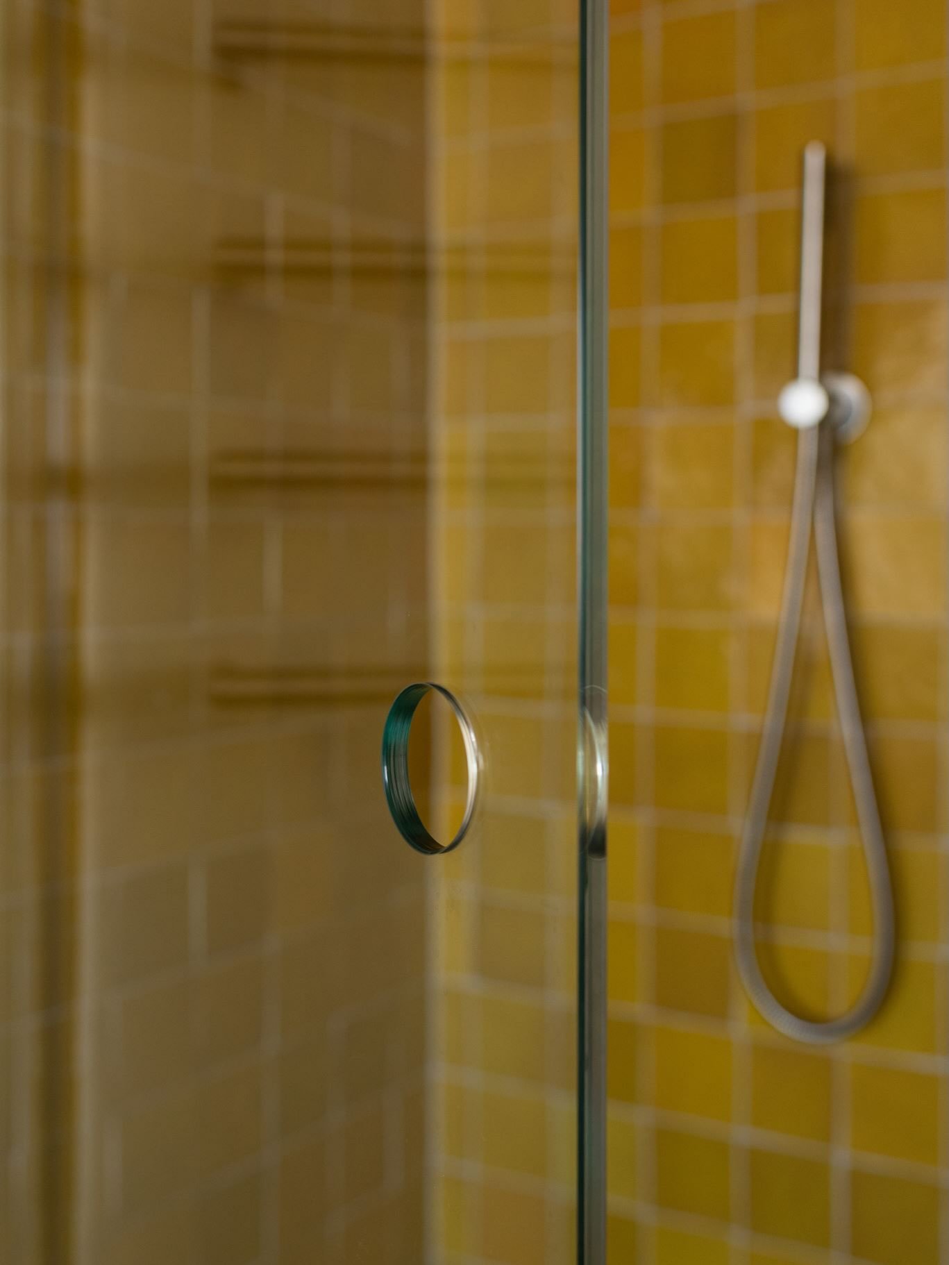 I love it when I can make functionality beautiful 💛. In this shower, I opted for a simple circular glass shower screen cut-out to open and close it. 

This removed the need for an applied knob or handle, and added a lovely sleek architectural detail