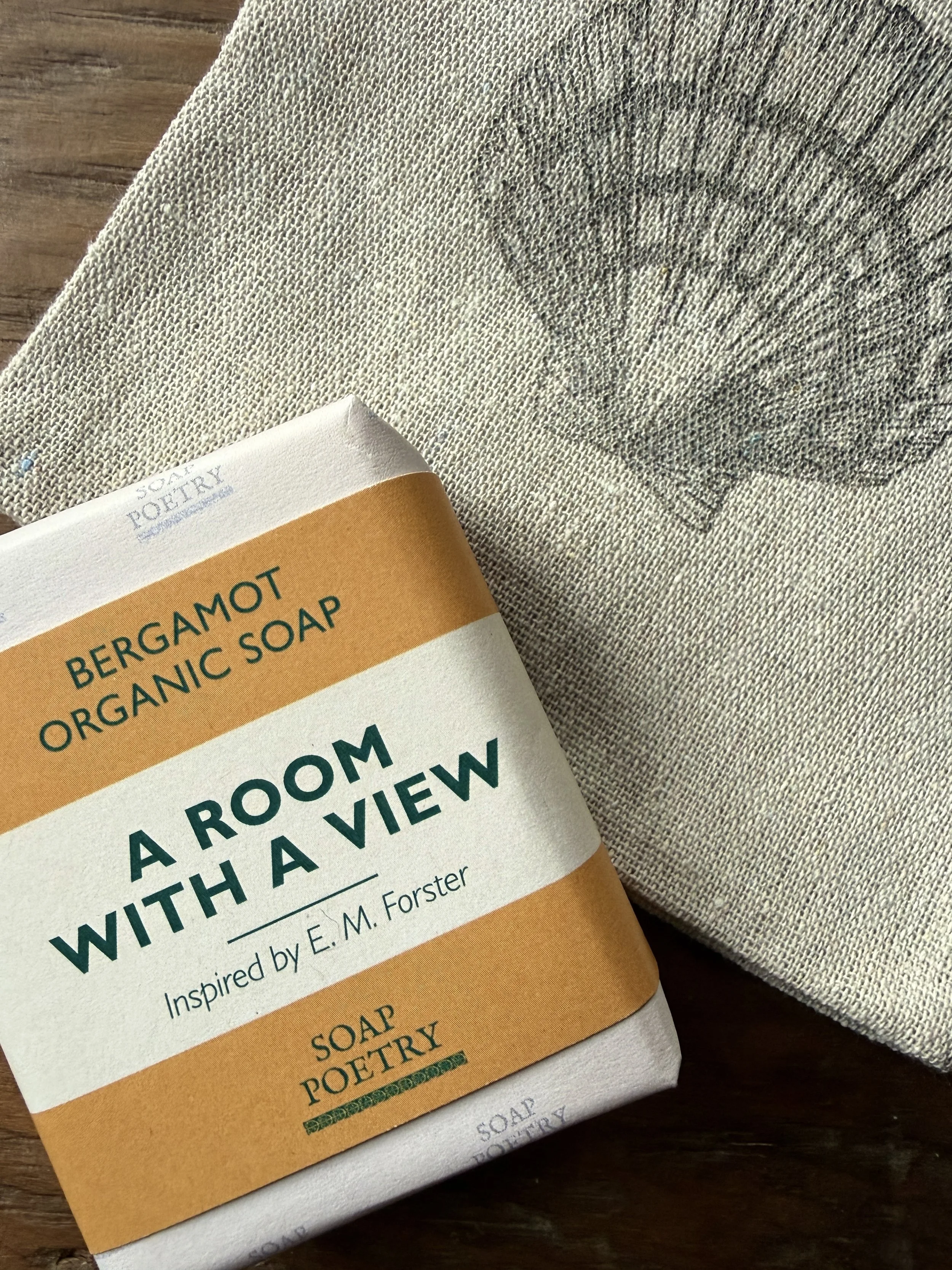 A bar of bergamot organic soap from independent brand Soap Poetry, on a wooden surface. Luxury welcome gifts for guests at The Dorset Nook. 