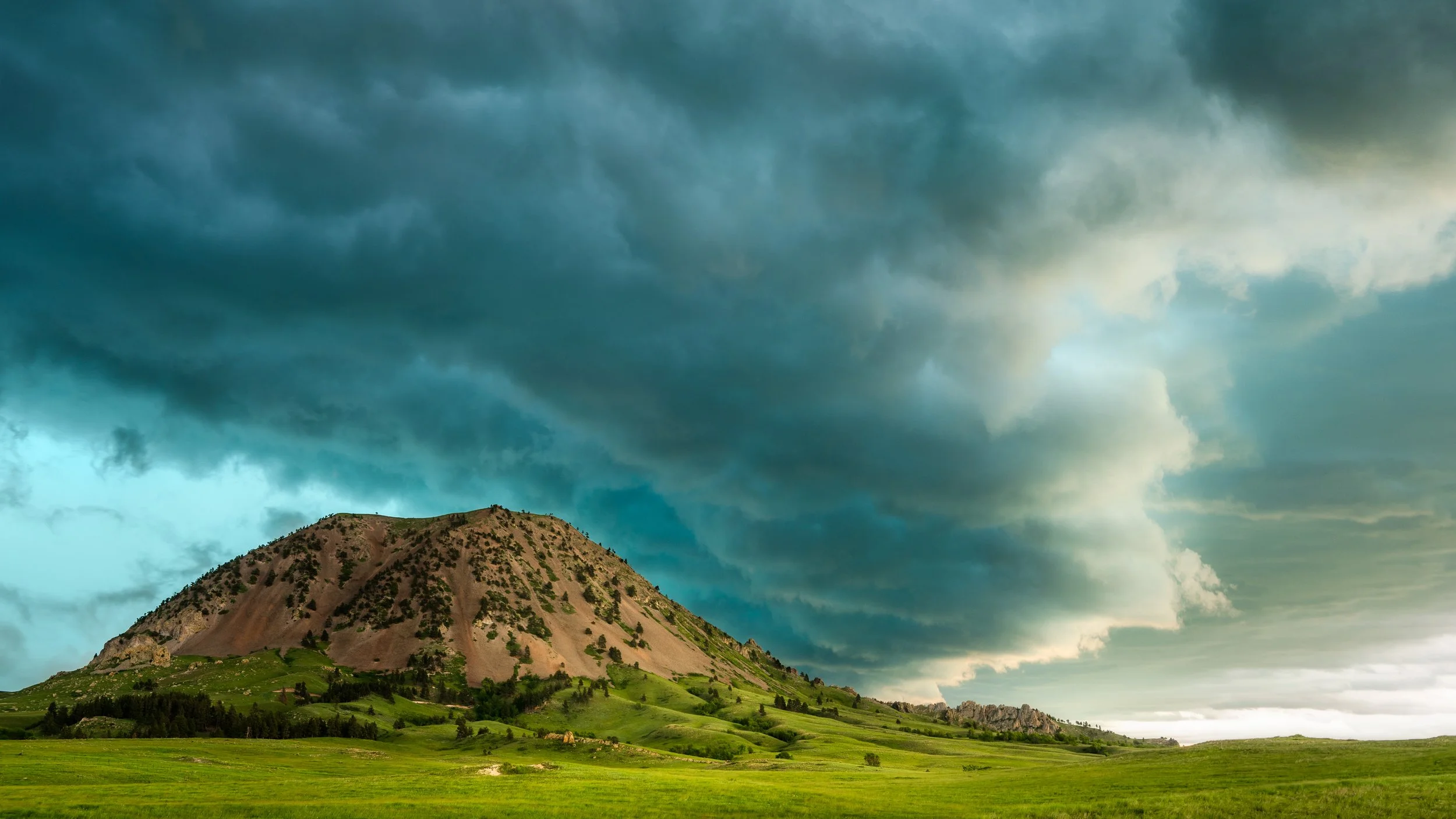 A beautiful blue shelf passes over Bear Butte South Dakota