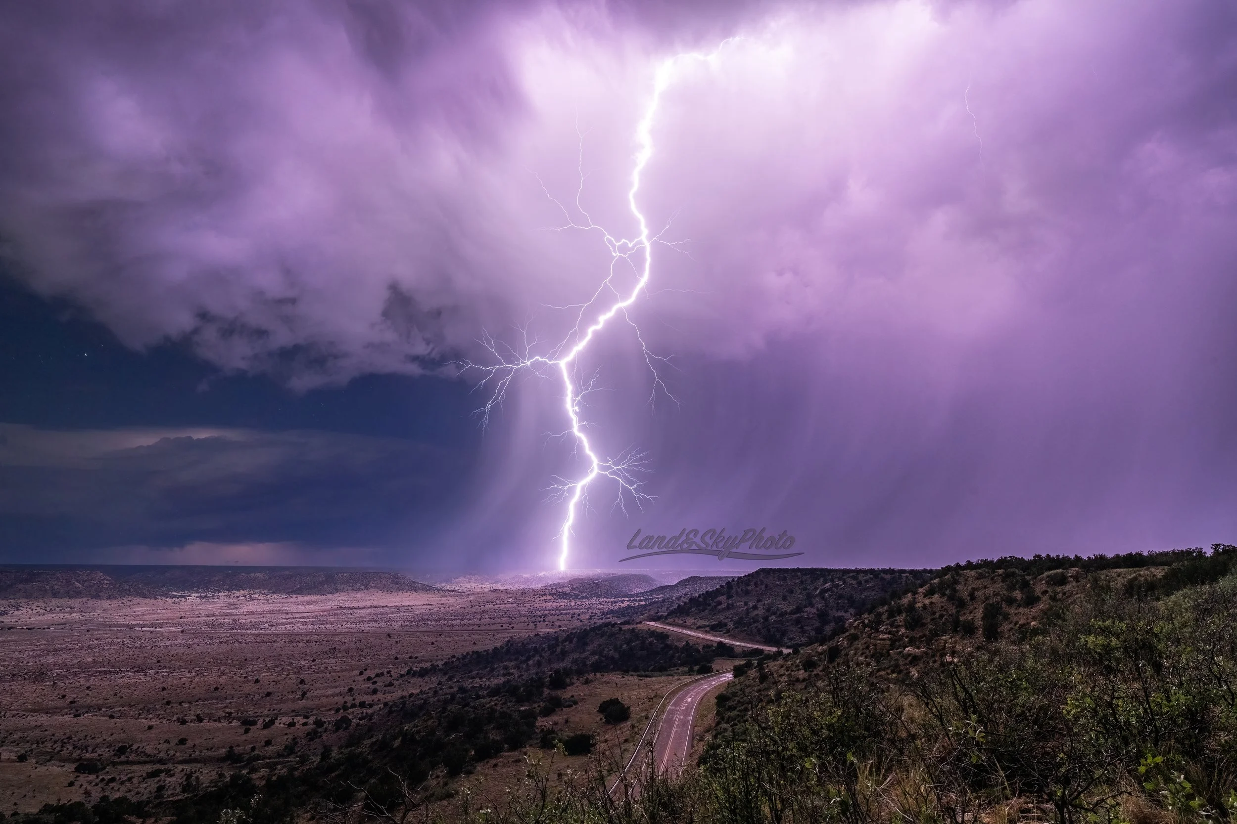A large lightning bolt strikes some plateaus near House, New Mexico
