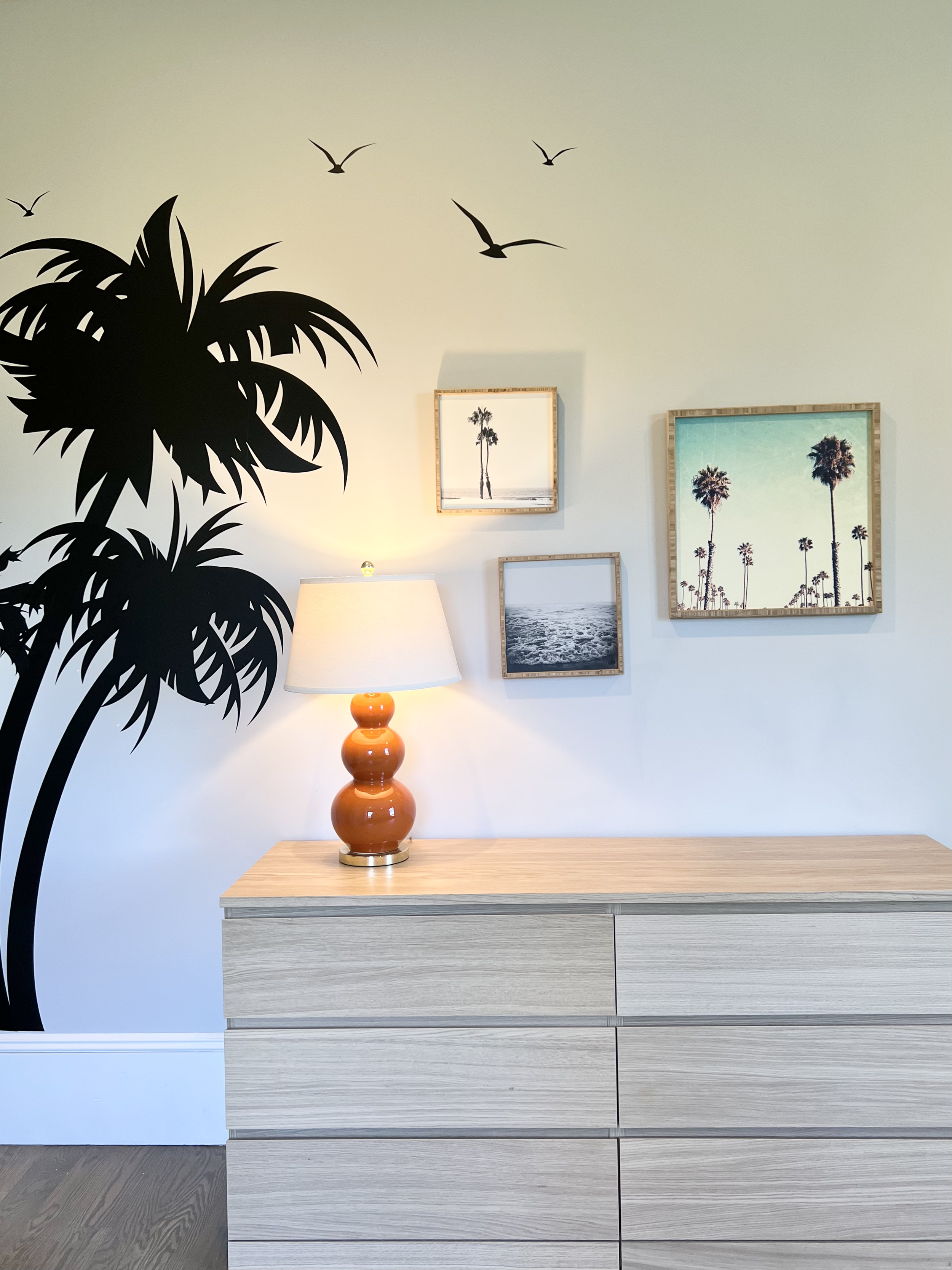 New decor for older child's bedroom including palm tree decal on wall and tropical art