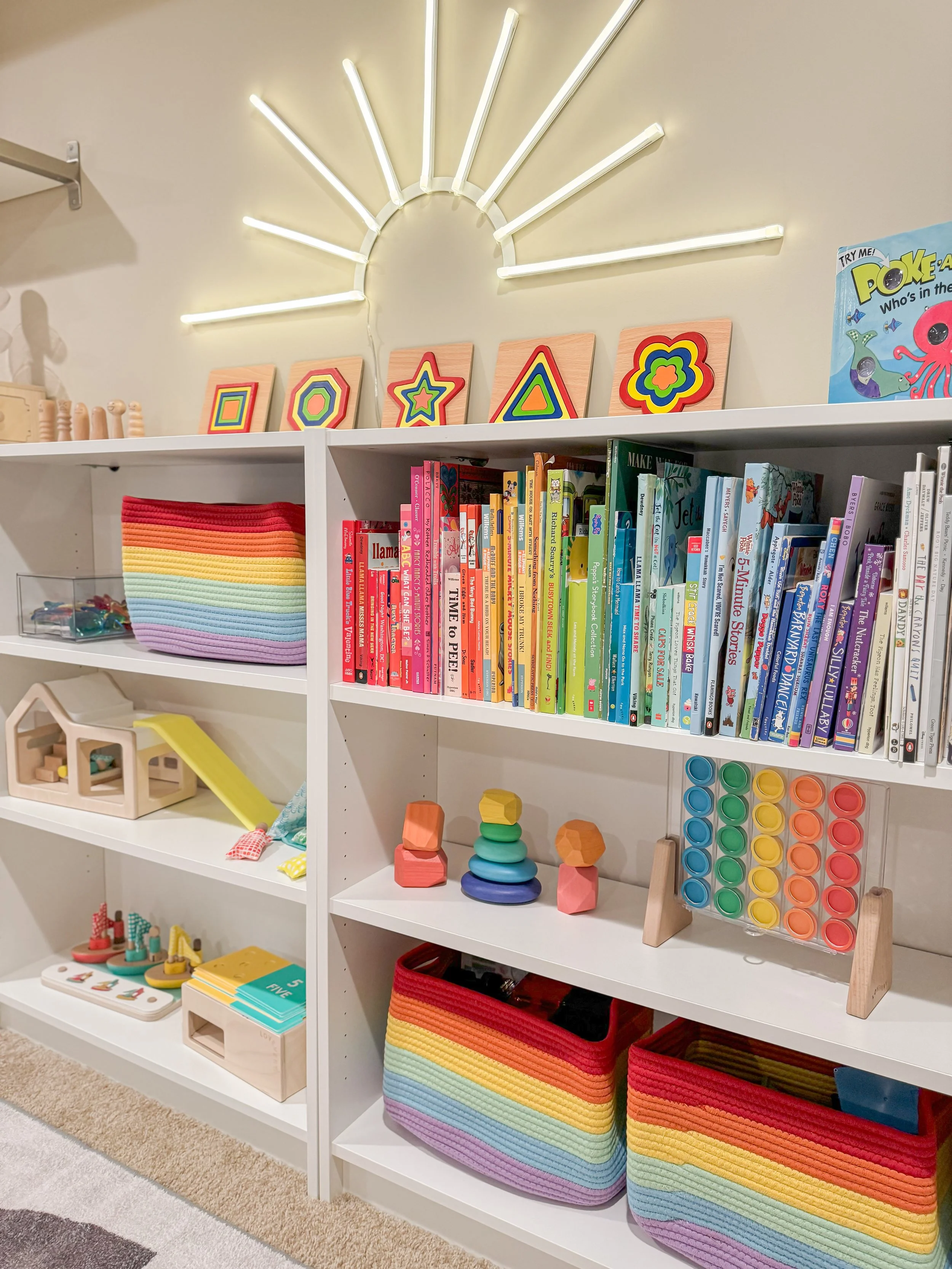 A child's bedroom with craft table by a window and organized dresser with a bookshelf.