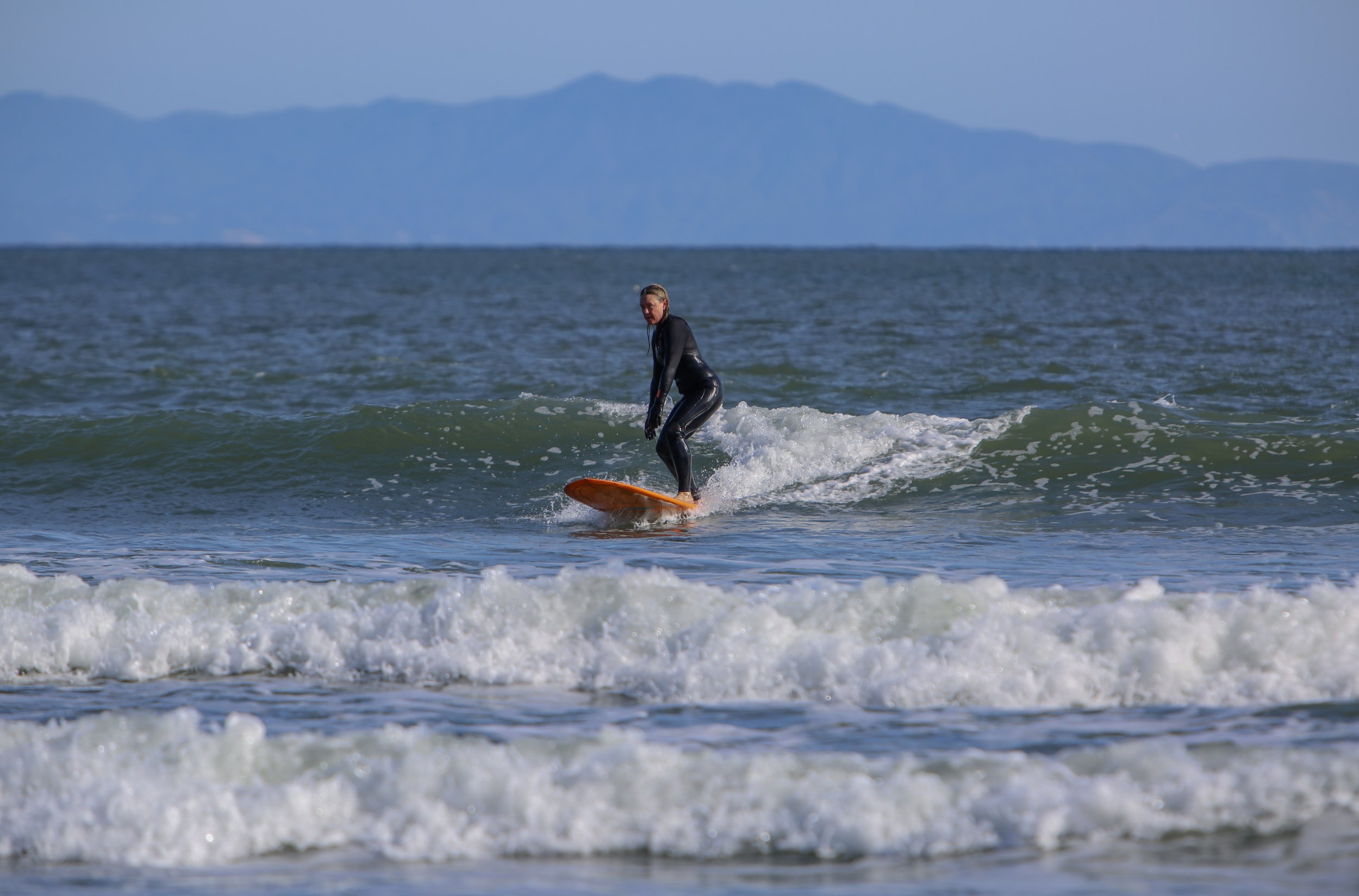 Balancing on her board, Calkins catches a wave at Bolinas Beach.