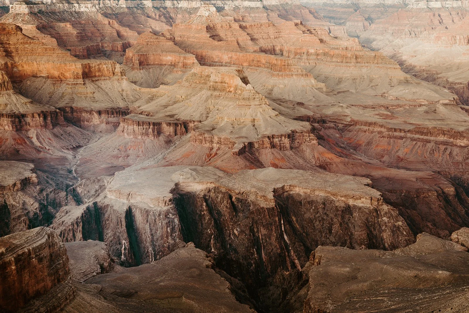 View of the Grand Canyon with layered rock formations and deep valleys.