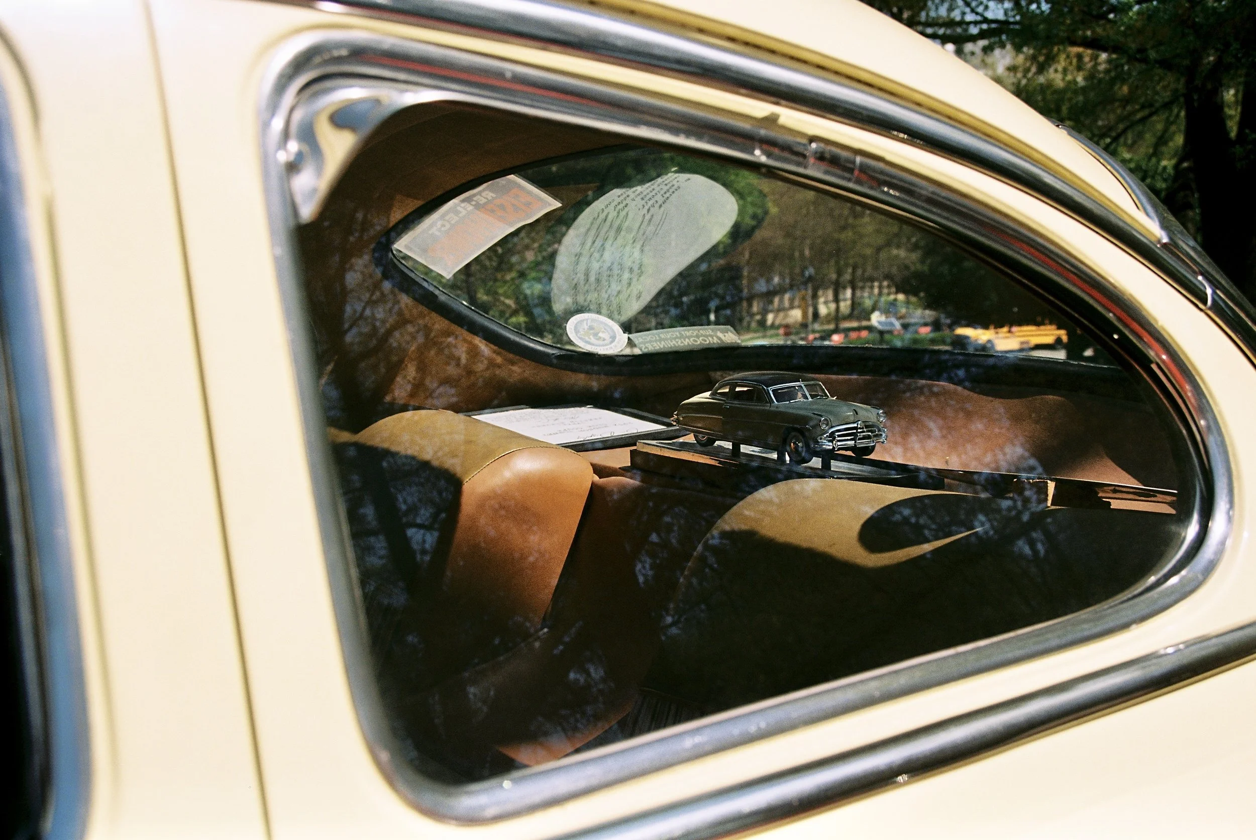 A classic car model inside of a classic car on the dash.