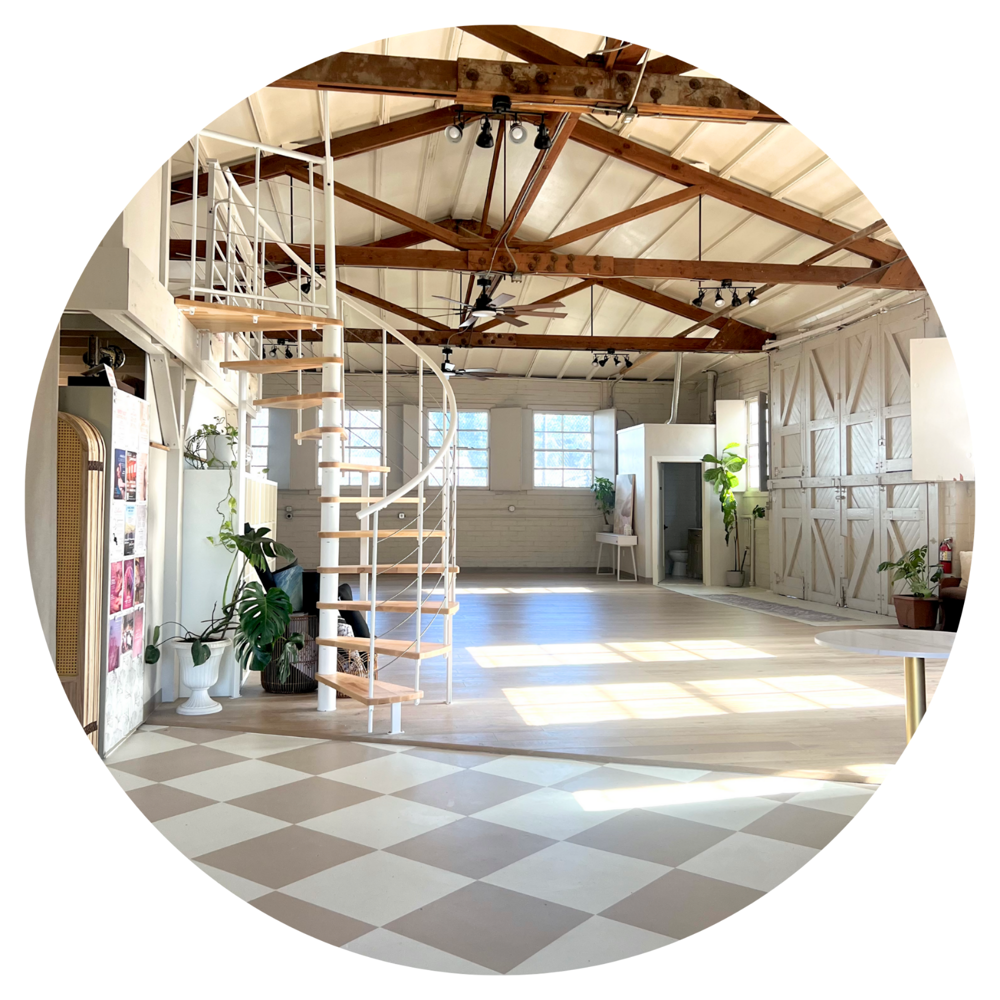 Interior with teal wall, neon sign "come as you are," gray sofa, plants, wooden floor, and exposed ceiling ducts.