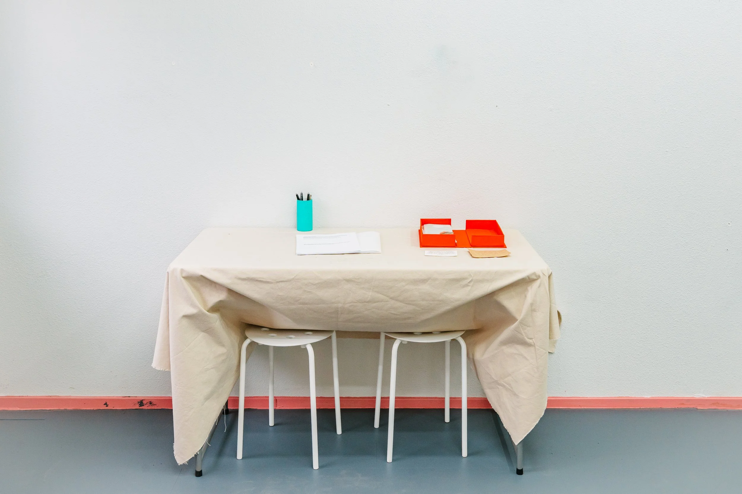 Installation view of a table which held the handmade portfolio box for viewers to touch and flip through. Rory Fitzgerald Bledsoe created questionnaires for community responses on surveillance and privacy.