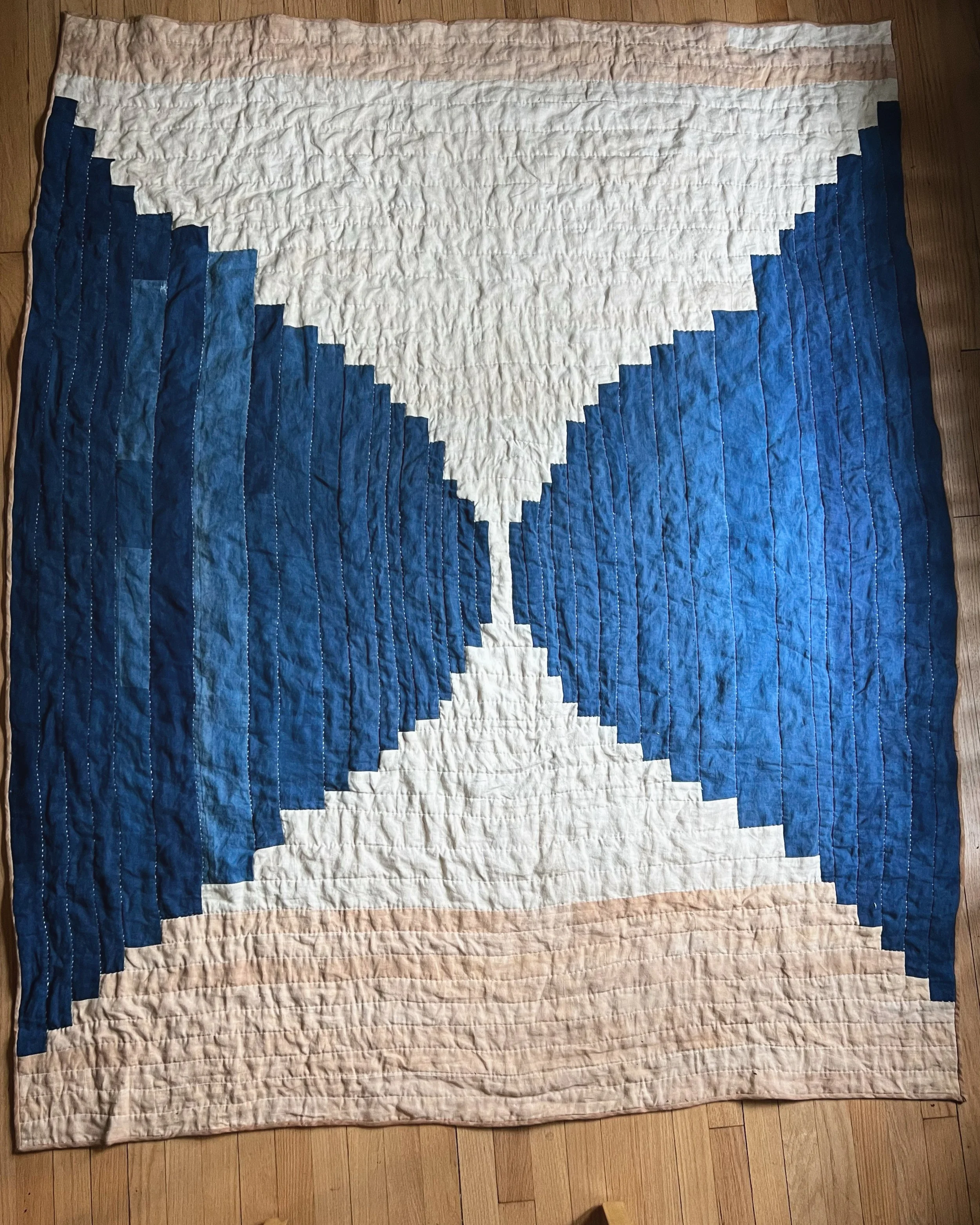 Quilt with geometric blue and white hourglass pattern