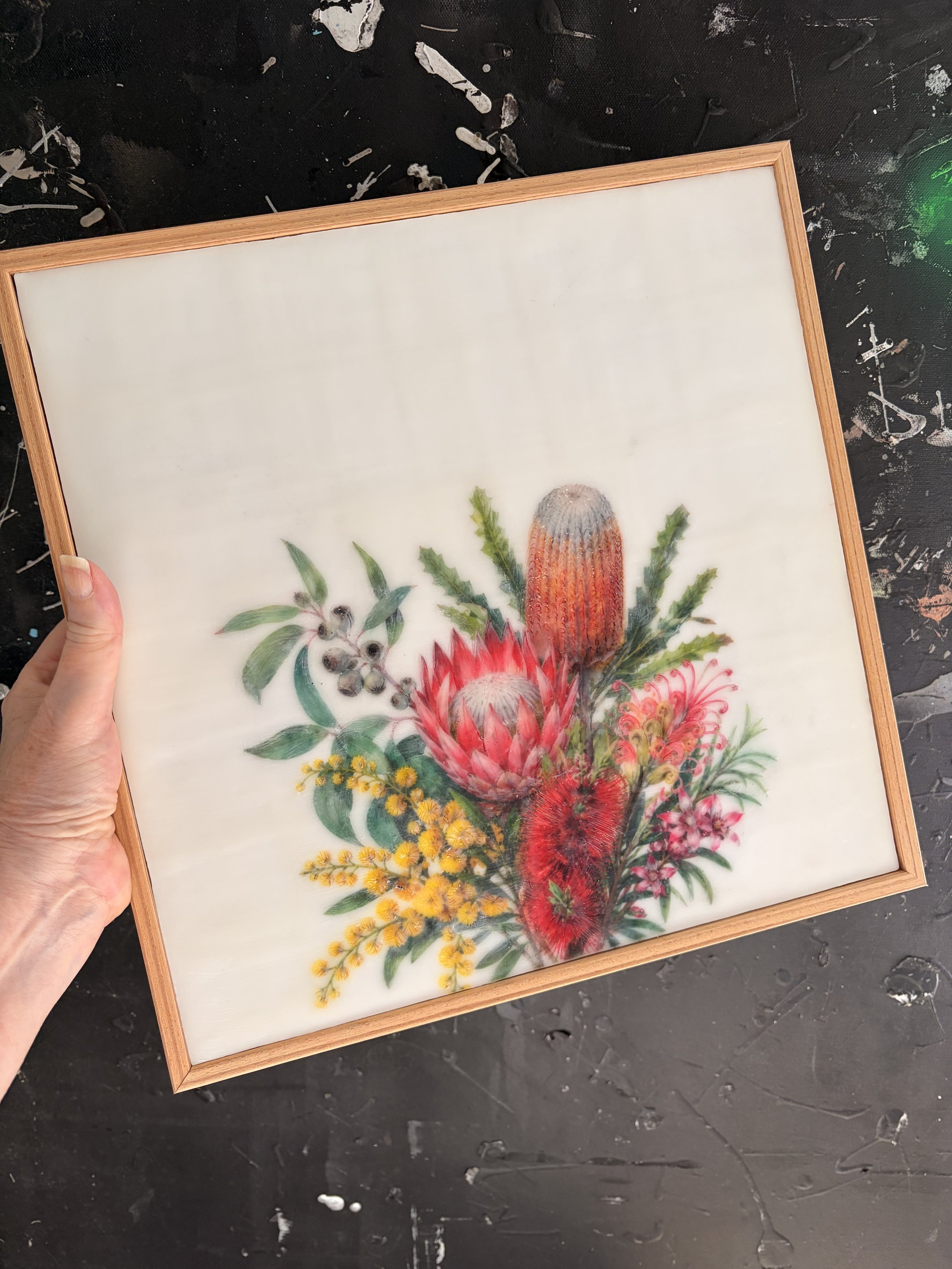 Encaustic wax and mixed media artwork featuring Australian native flowers including banksia, protea, bottlebrush and wattle on a soft ivory background, framed in natural timber.