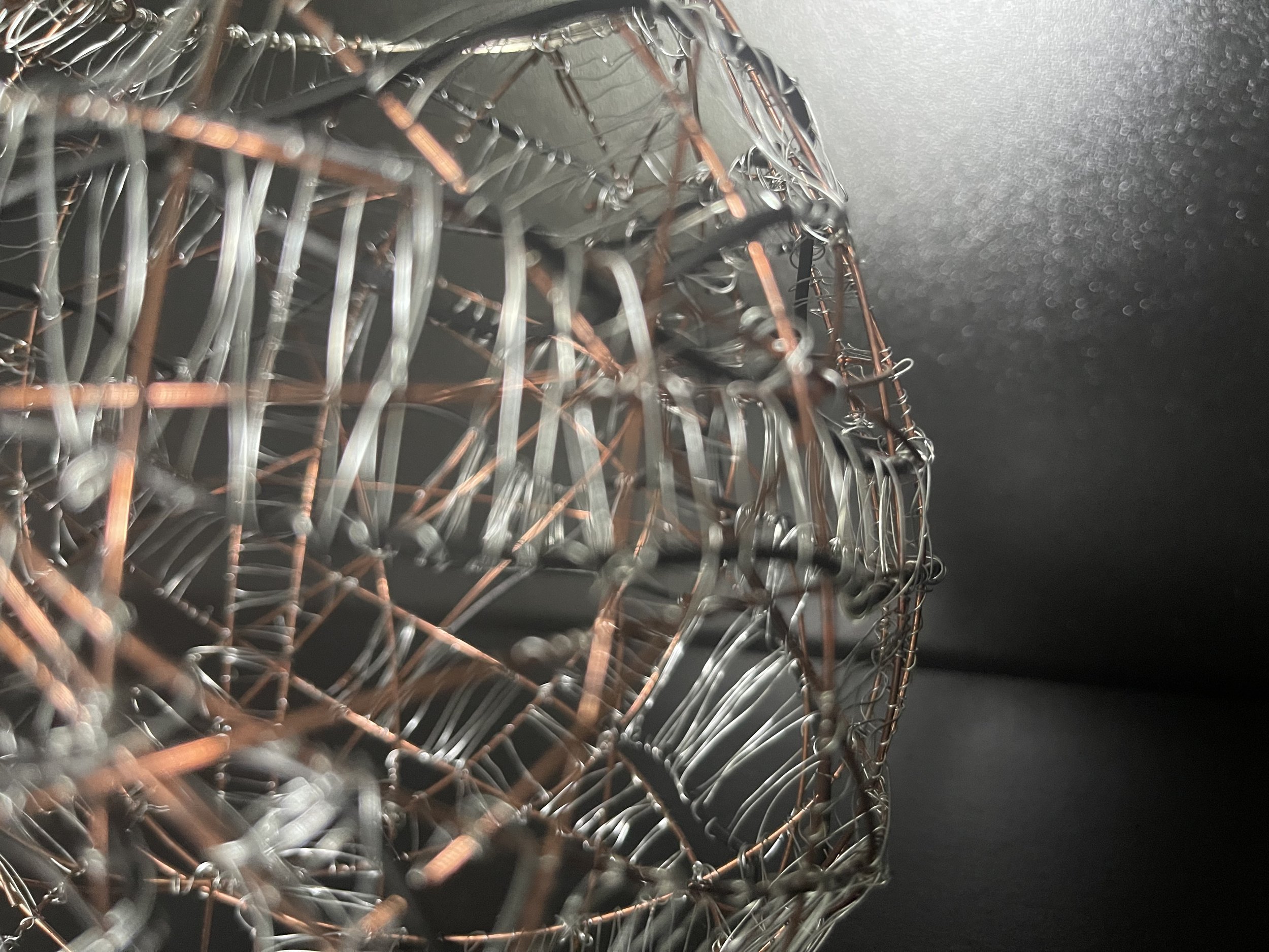 Small wire sculpture made of copper, black and silver wire.