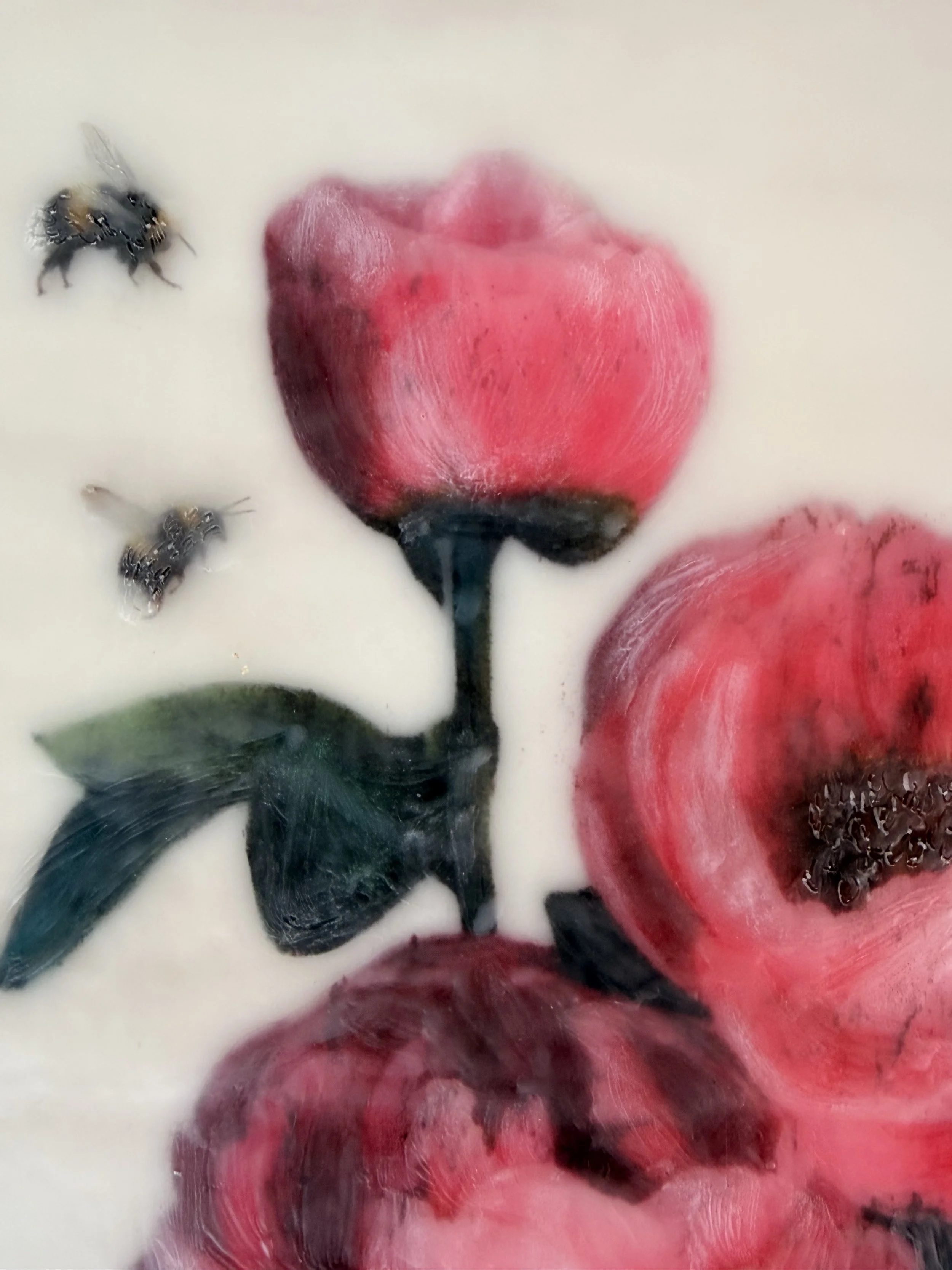 an encaustic wax/mixed media artwork of soft pink flowers and two bees