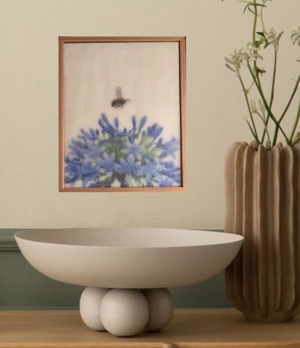 Original encaustic wax artwork featuring a softly rendered honeybee hovering above vibrant blue agapanthus flowers. Dreamy botanical artwork with luminous beeswax layers, framed