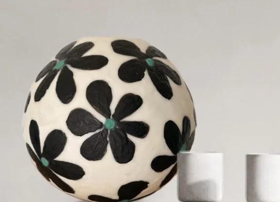 Handmade encaustic wax bowl featuring black floral motifs on a white rounded form, created by artist Karen Canning.