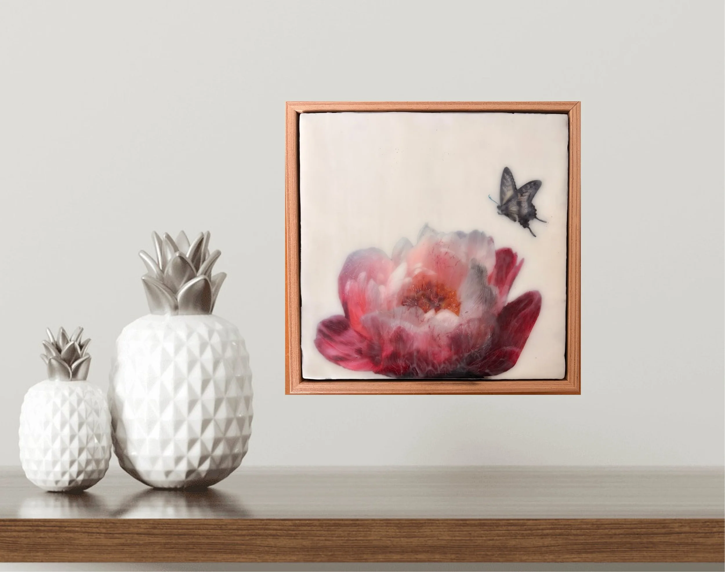 Encaustic wax artwork of a soft pink and crimson flower with a butterfly hovering above, featuring layered wax textures and a gentle, dreamlike finish.