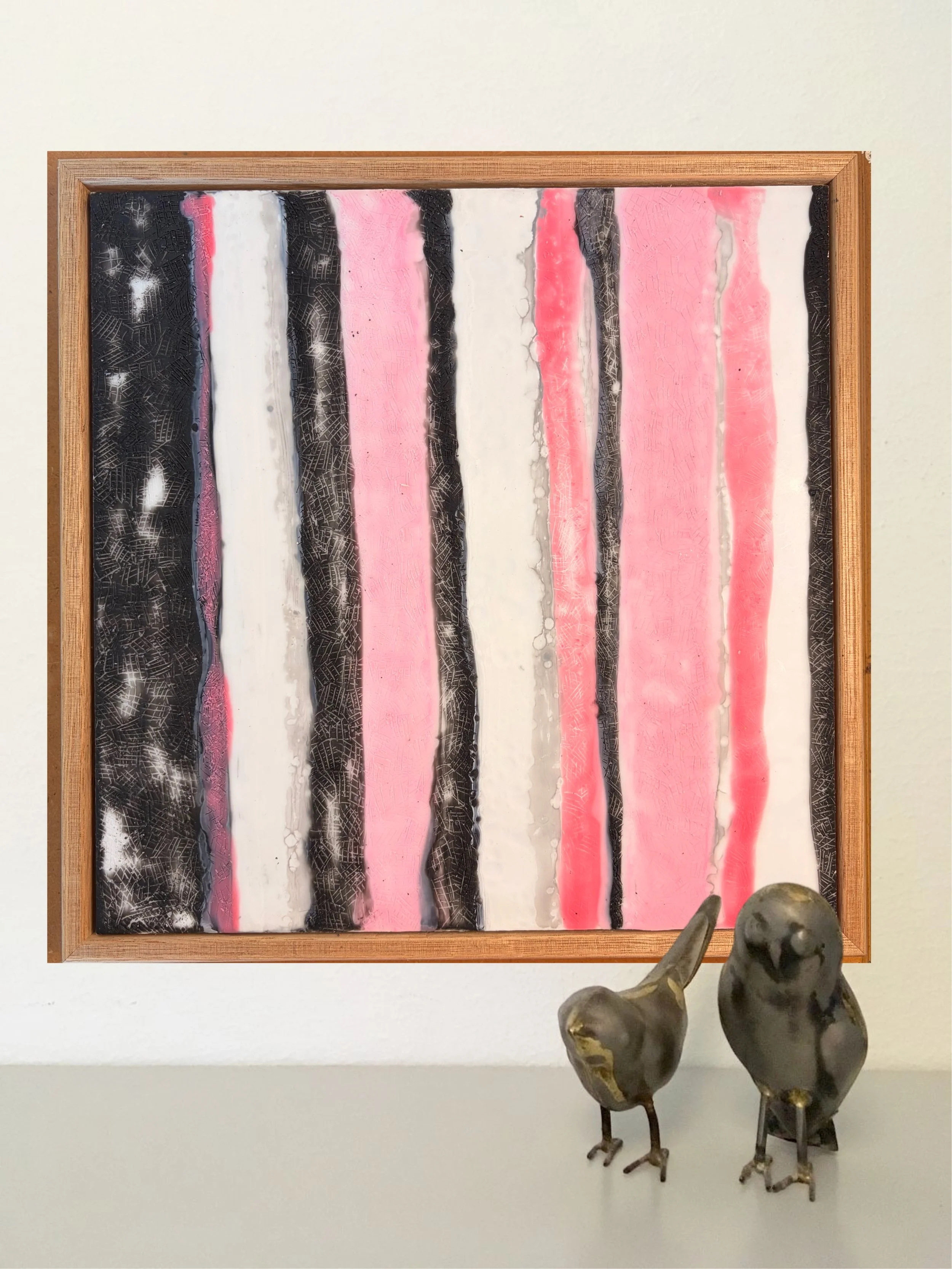 Close-up and full views of a framed encaustic wax artwork featuring vertical pink, black, and white textured stripes, displayed in a timber frame on a light background.