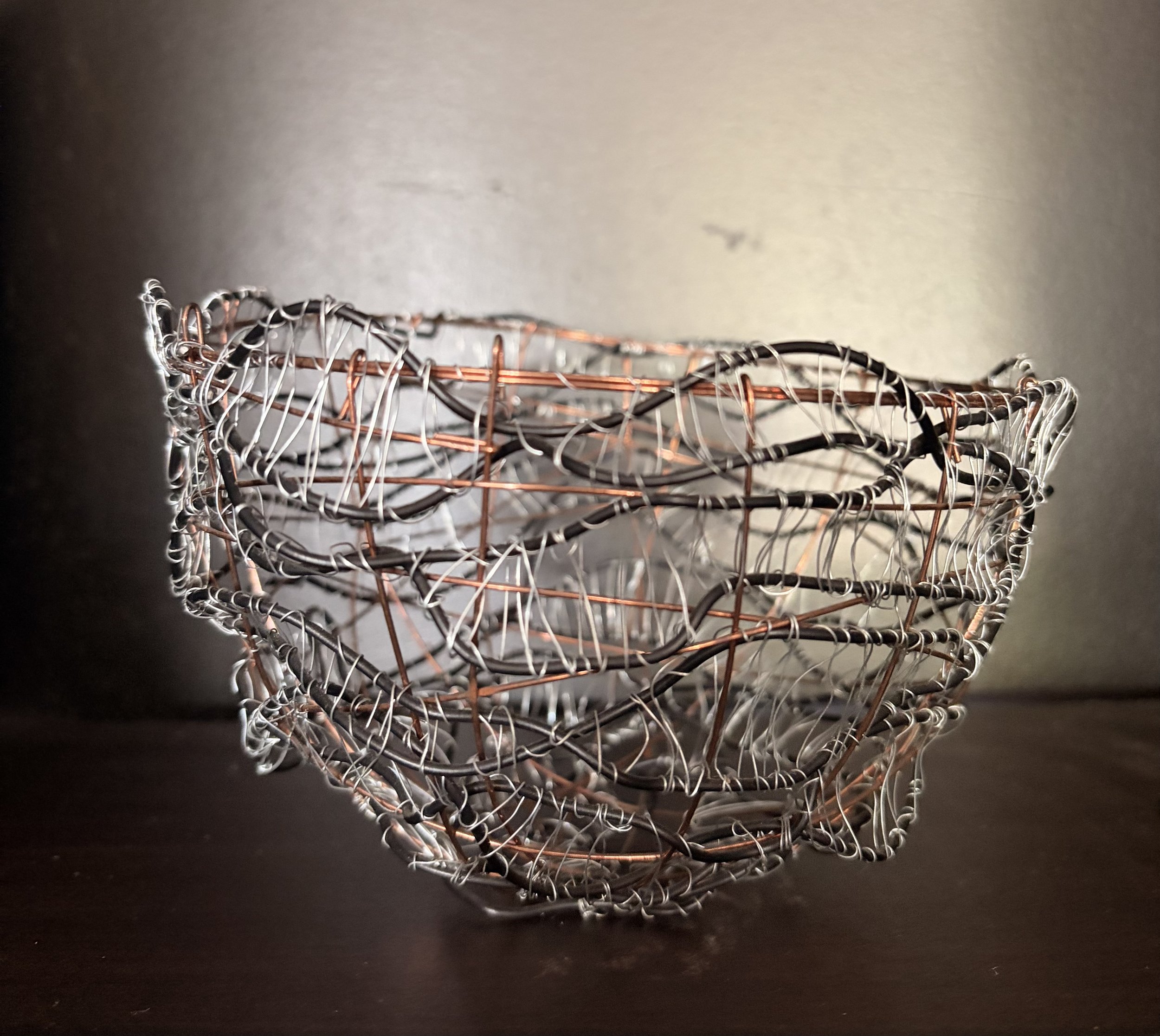 Handcrafted wire sculpture bowl made from copper and steel wire, featuring an organic woven design with layered textures, displayed as a contemporary sculptural vessel.