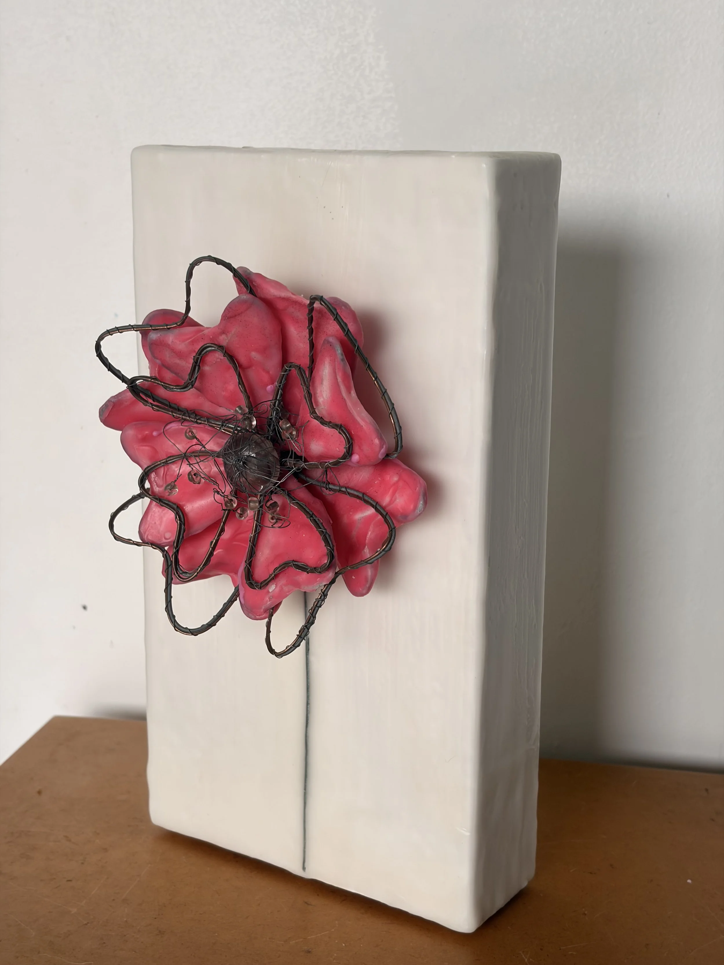 Encaustic wax and wire flower artwork mounted on a creamy white wax block