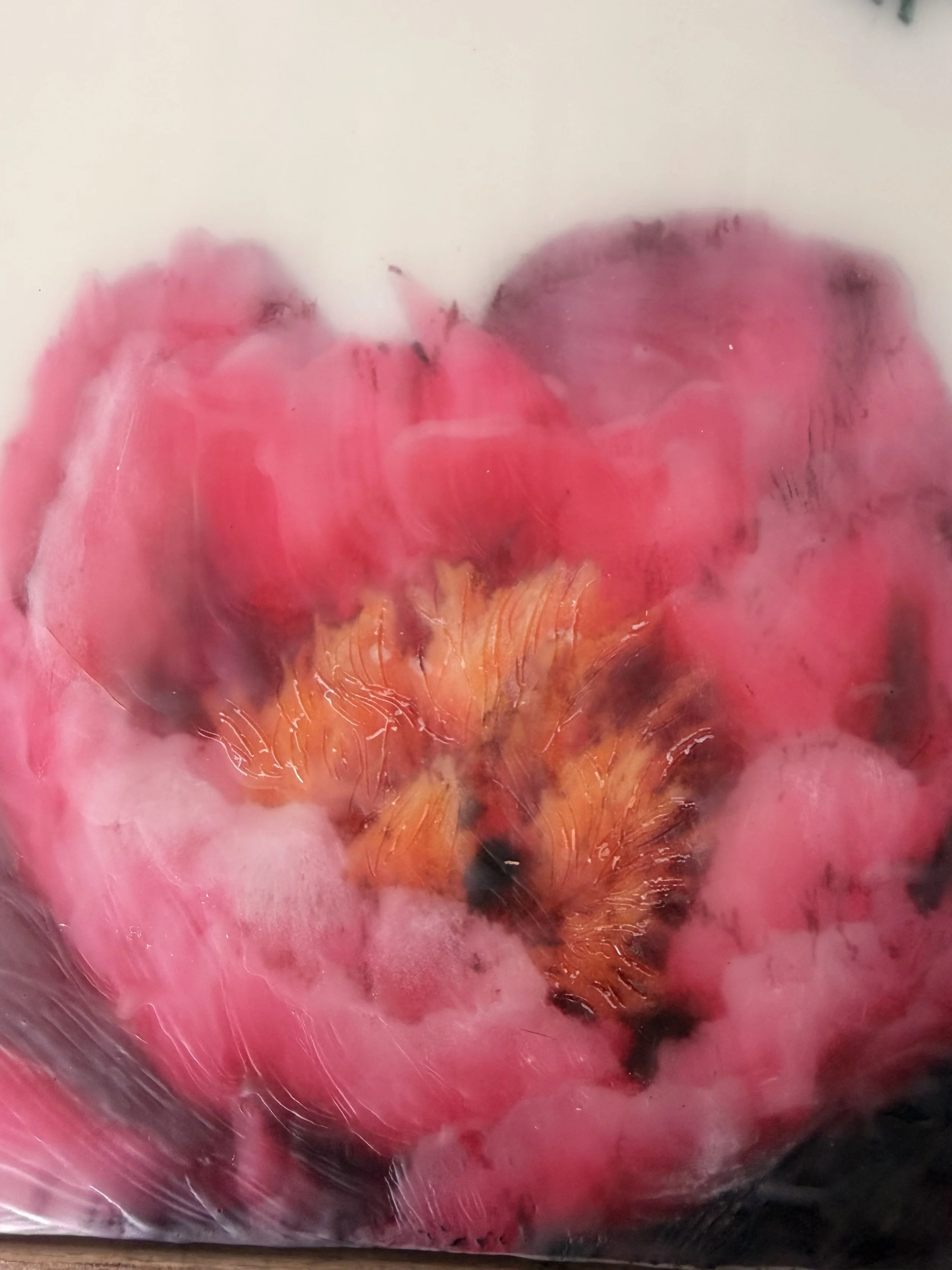 Encaustic wax artwork of a soft pink flower with a delicate butterfly hovering above, created with layered wax textures and gentle blended tones.