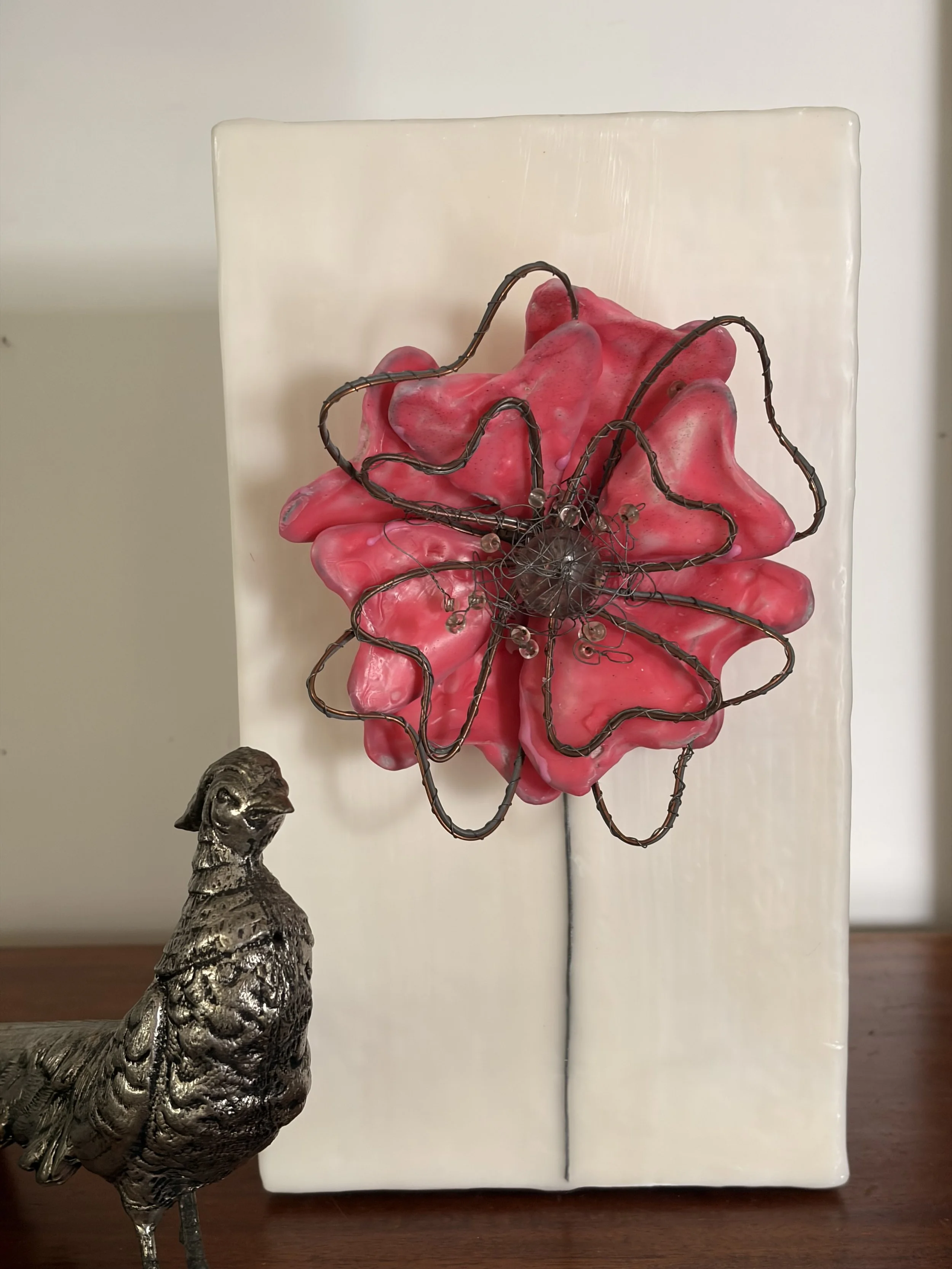 Encaustic wax and wire flower artwork mounted on a creamy white wax block