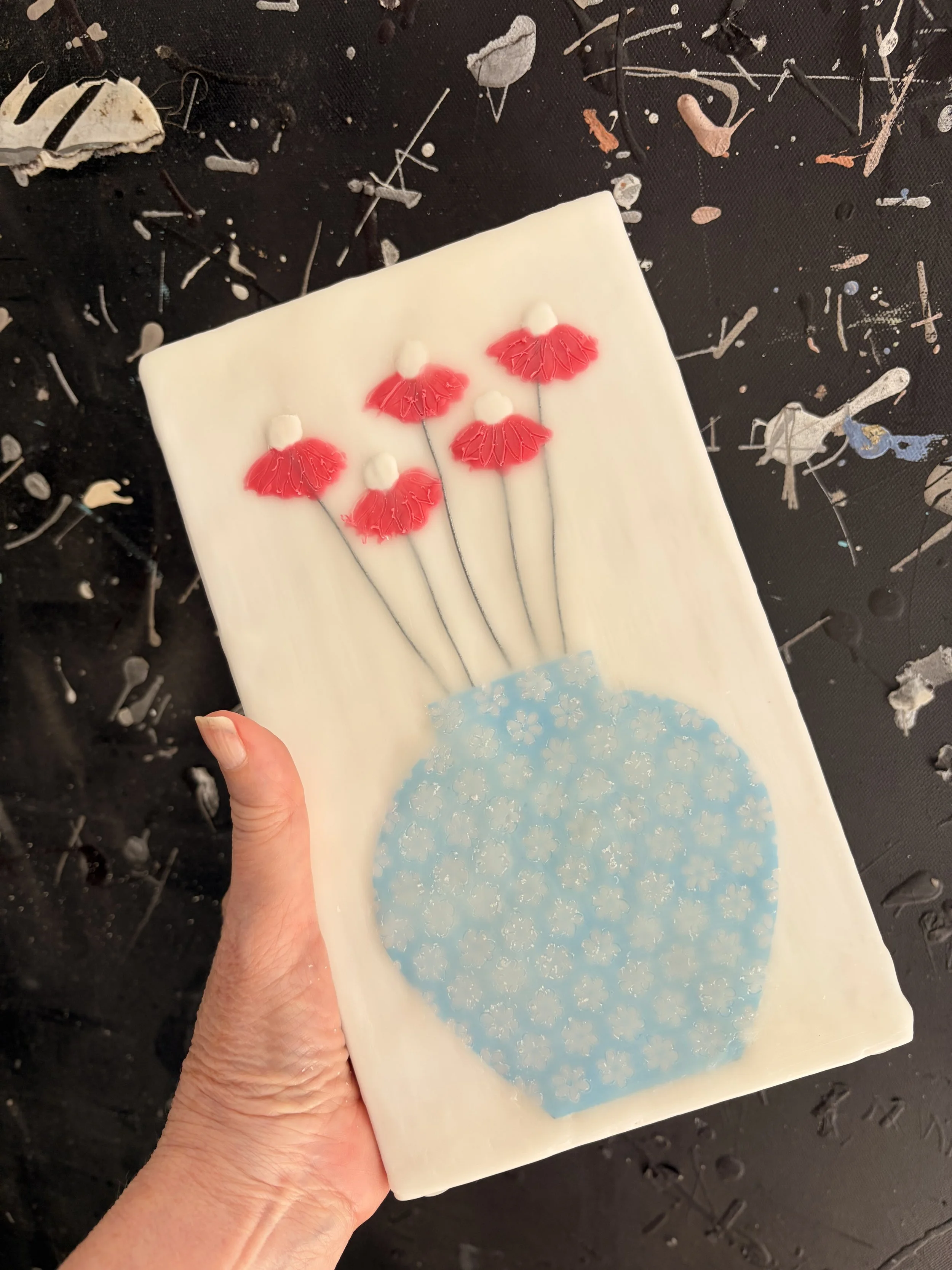 Encaustic wax and mixed media block artworks featuring stylised vases with delicate pink and orange flowers on textured white backgrounds, arranged as a cohesive decorative series.