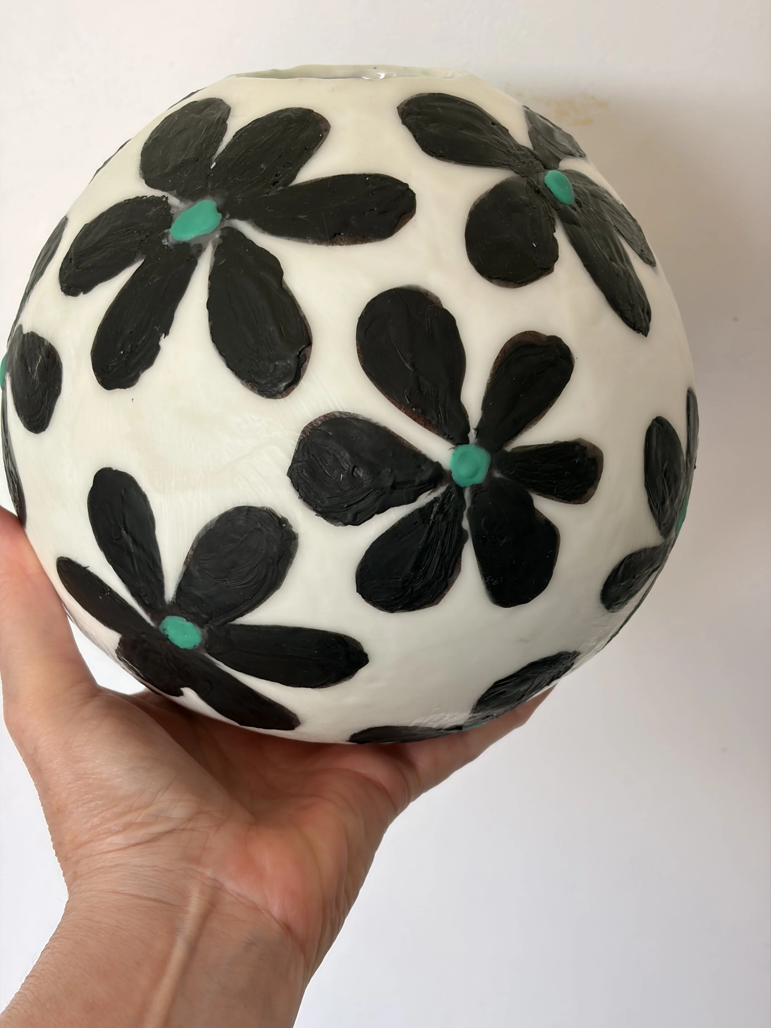 Handmade encaustic wax bowl featuring black floral motifs on a white rounded form, created by artist Karen Canning.