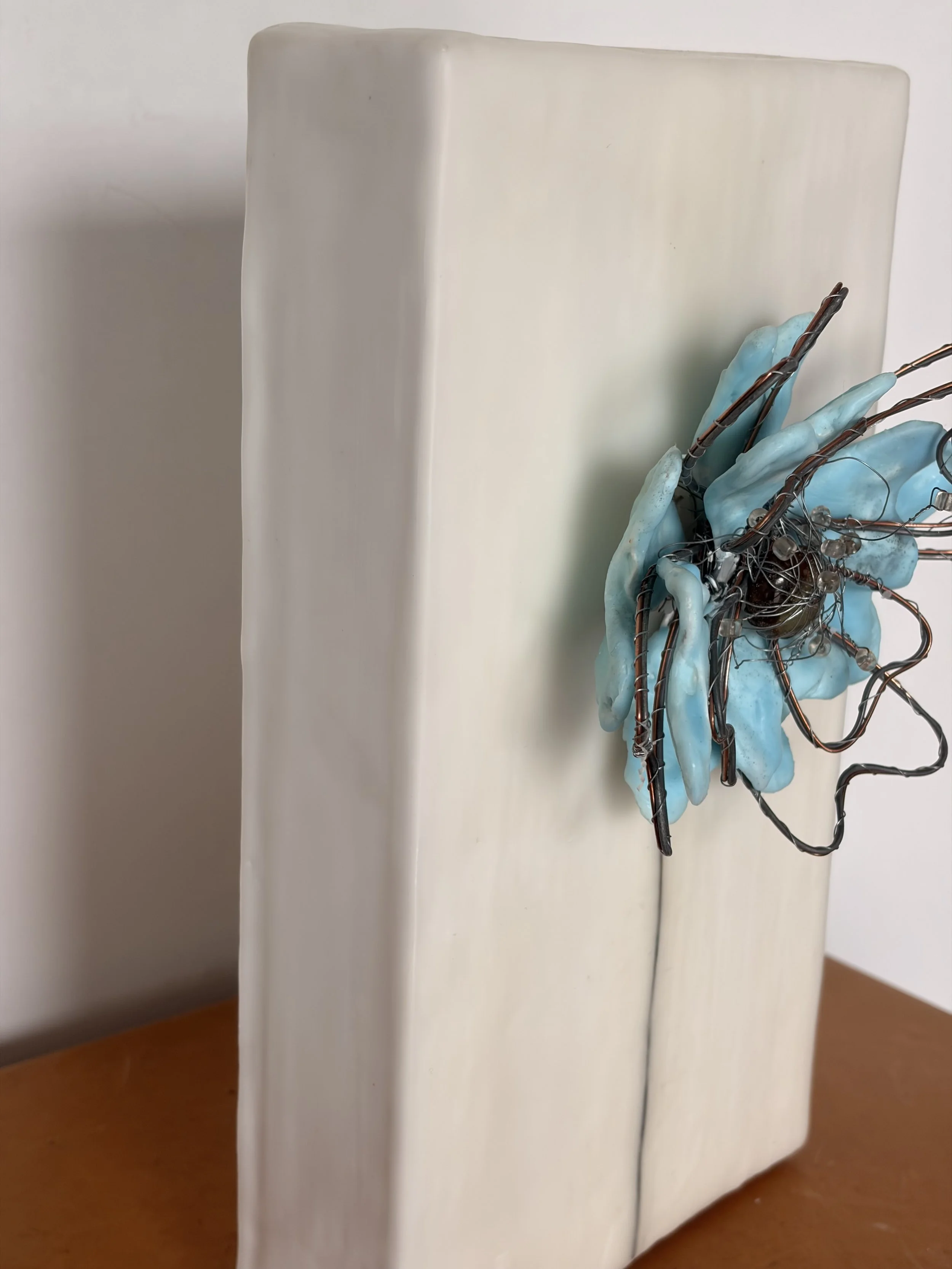 Side view of sculptural encaustic wax flower showing depth and texture