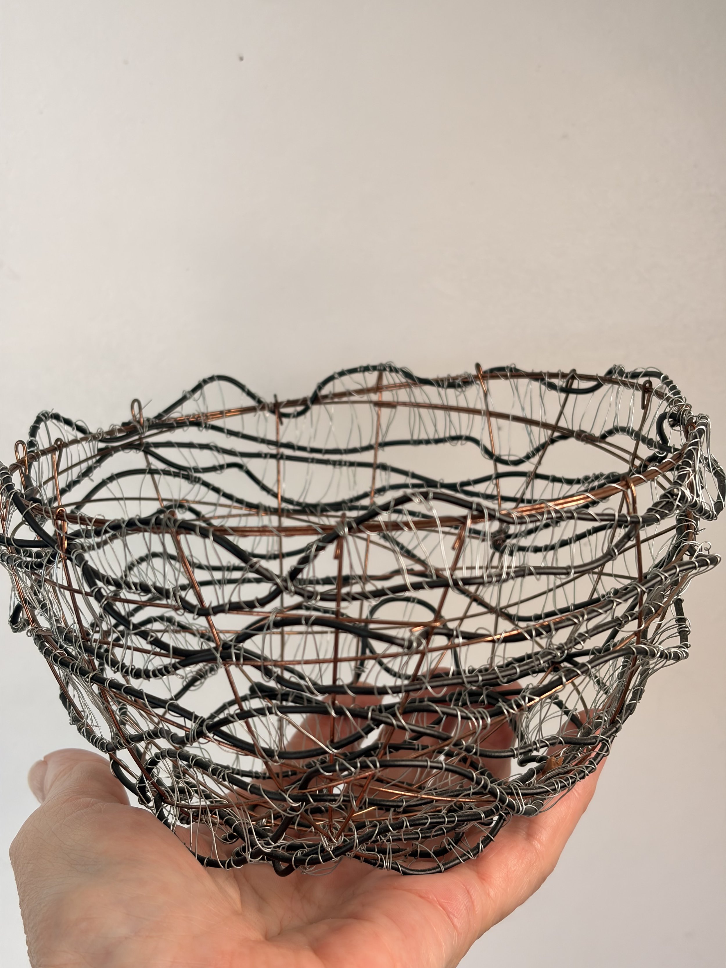 Handcrafted wire sculpture bowl made from copper and steel wire, featuring an organic woven design with layered textures, displayed as a contemporary sculptural vessel.