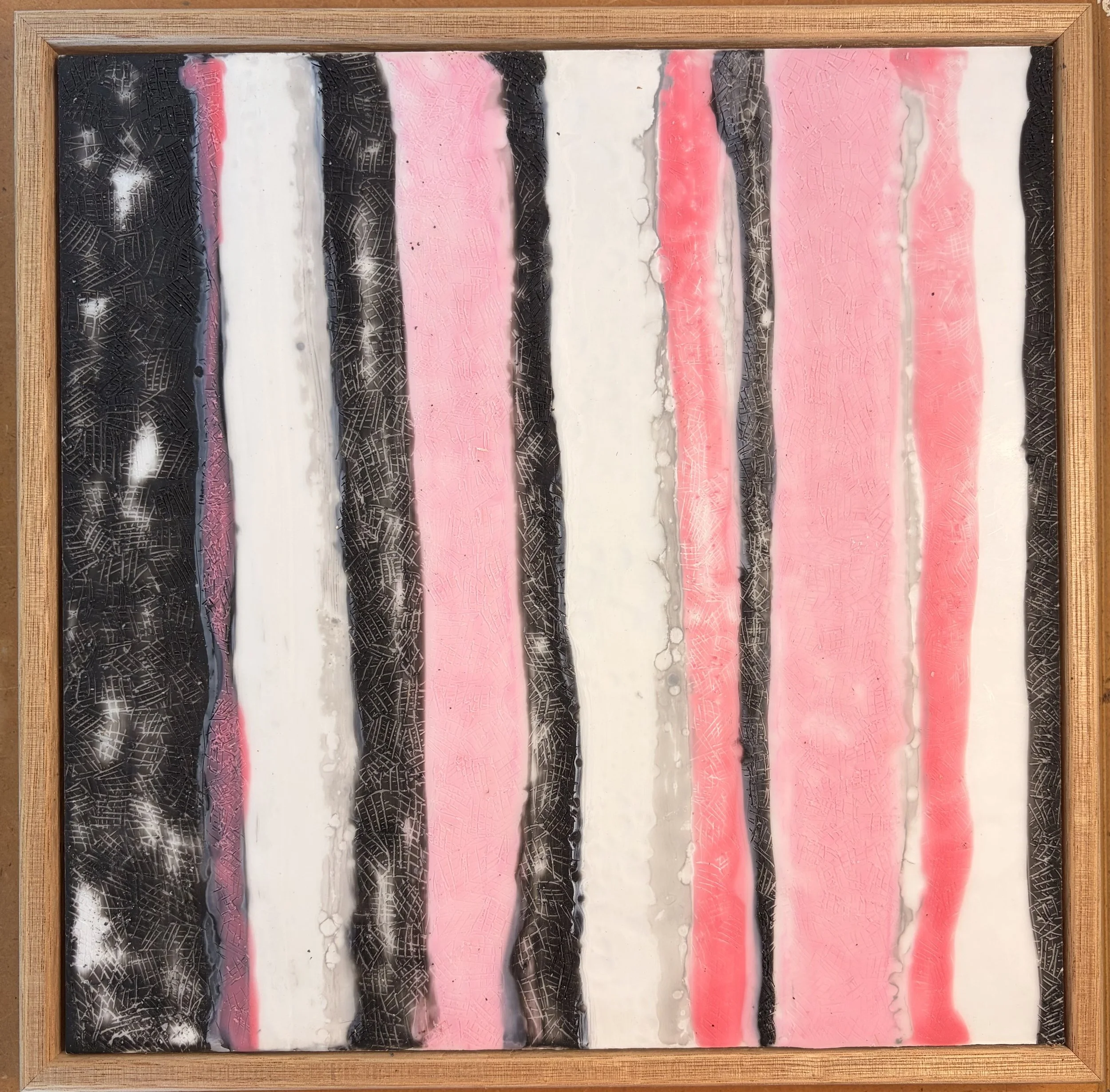 Close-up and full views of a framed encaustic wax artwork featuring vertical pink, black, and white textured stripes, displayed in a timber frame on a light background.