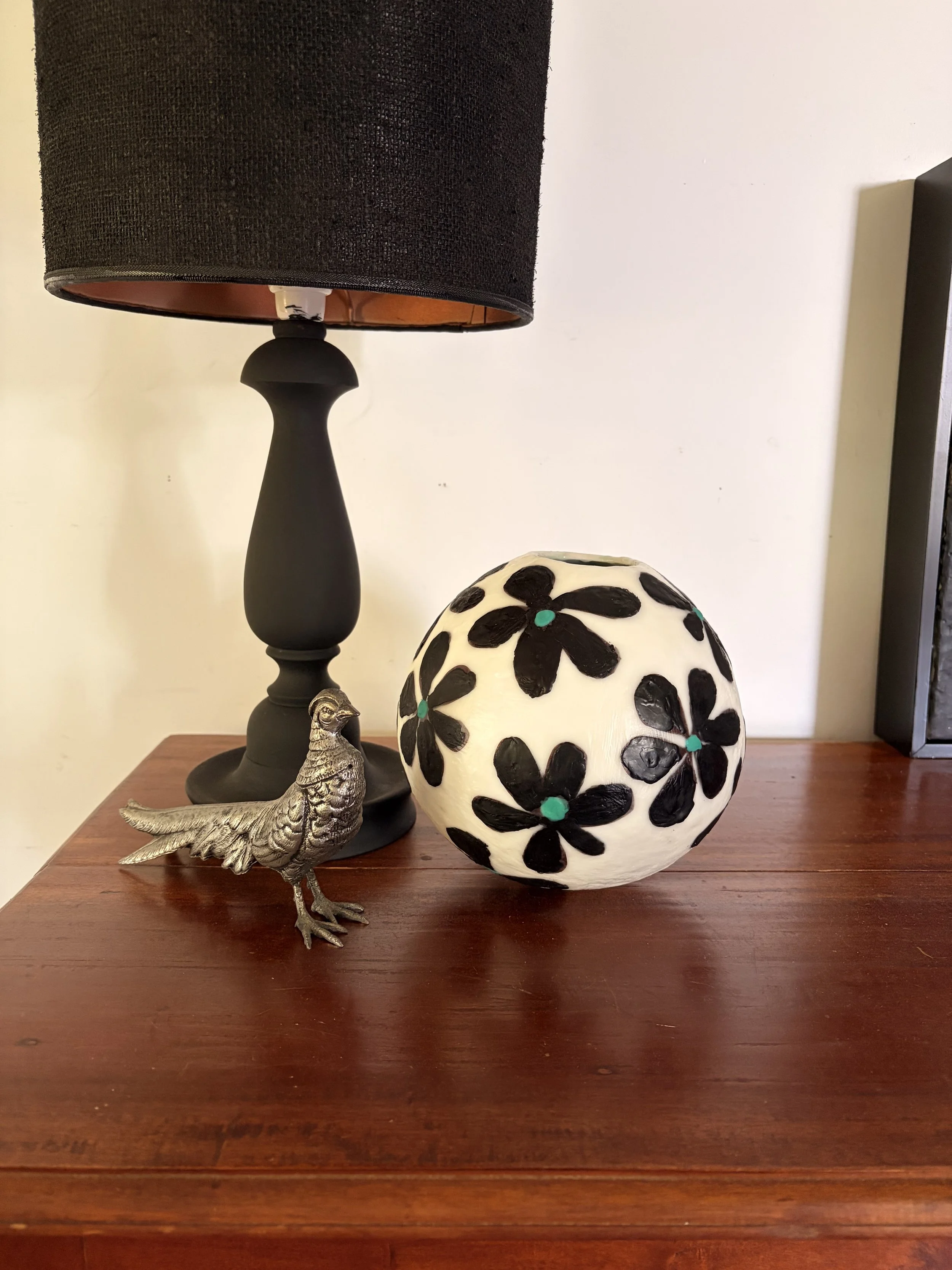 Handmade encaustic wax bowl featuring black floral motifs on a white rounded form, created by artist Karen Canning.