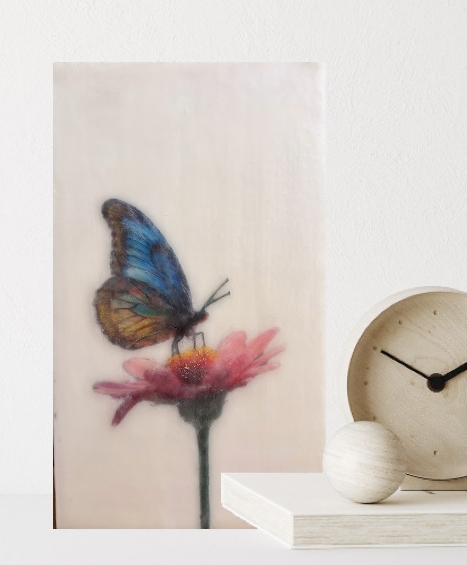 A blue and gold butterfly resting on a pink flower, rendered in luminous encaustic wax and mixed media with a dreamy, ethereal finish.
